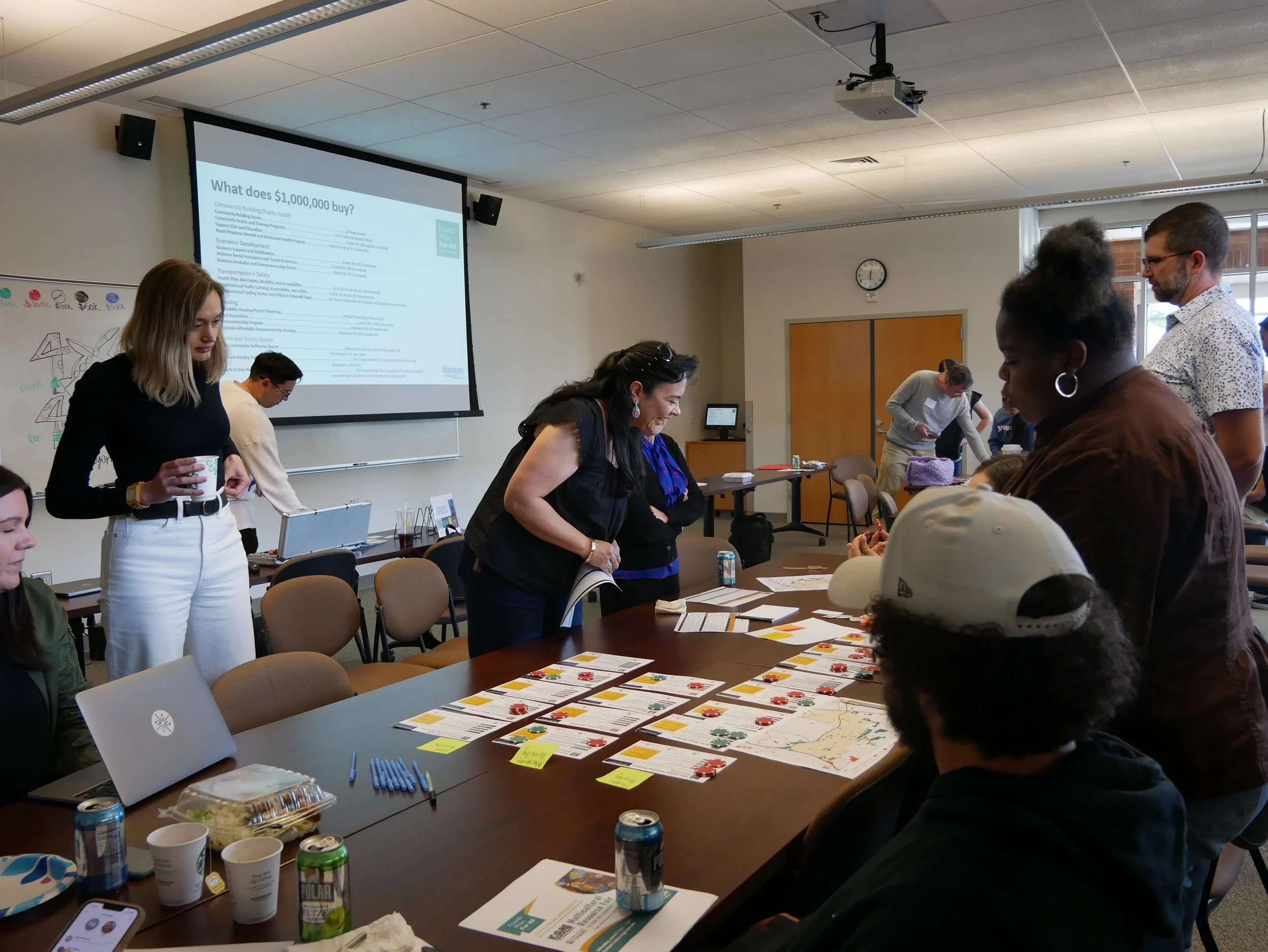 An image of people surrounding a long table with documents spread out on it
