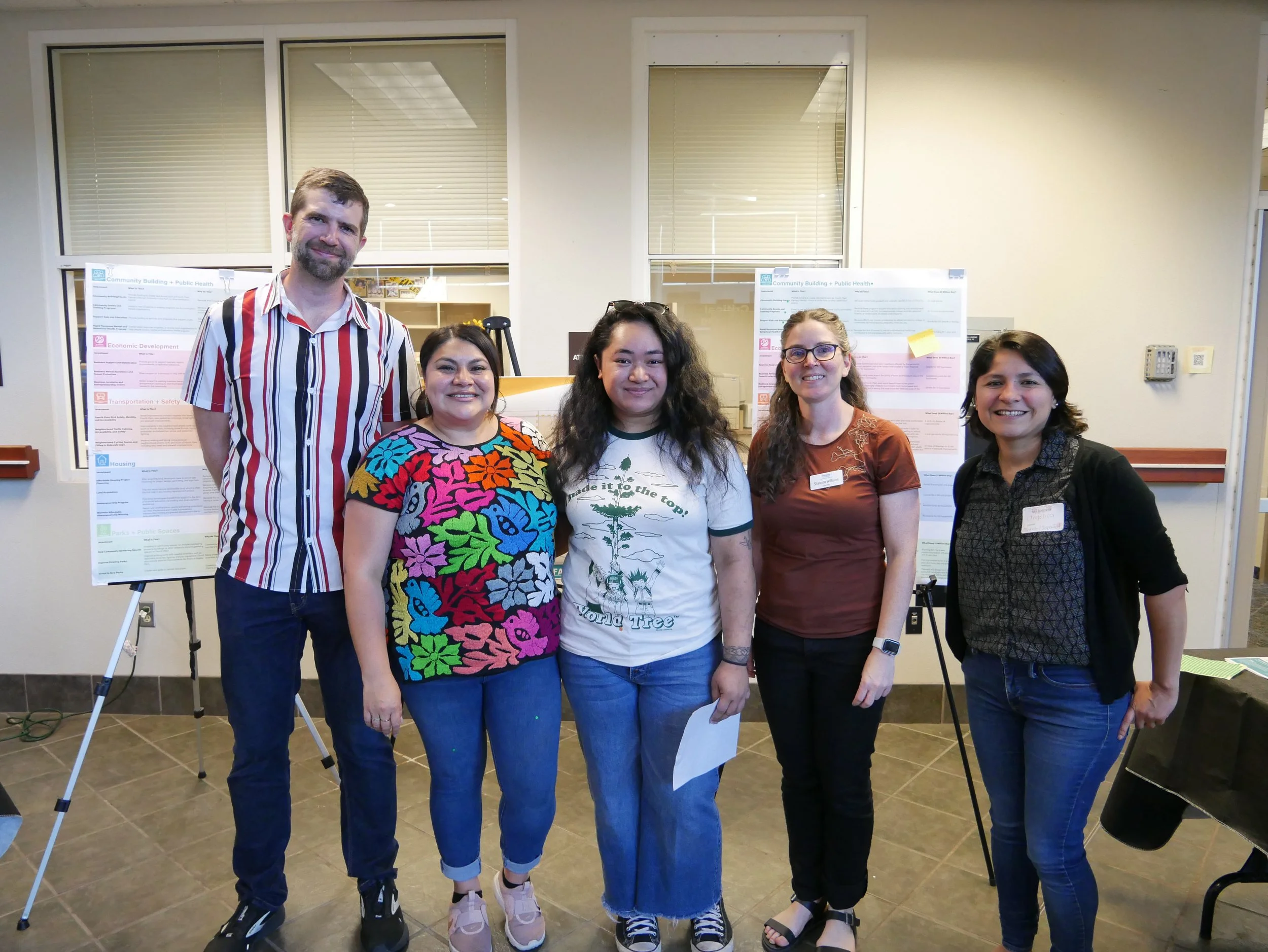 An image of five people standing together in front of display boards