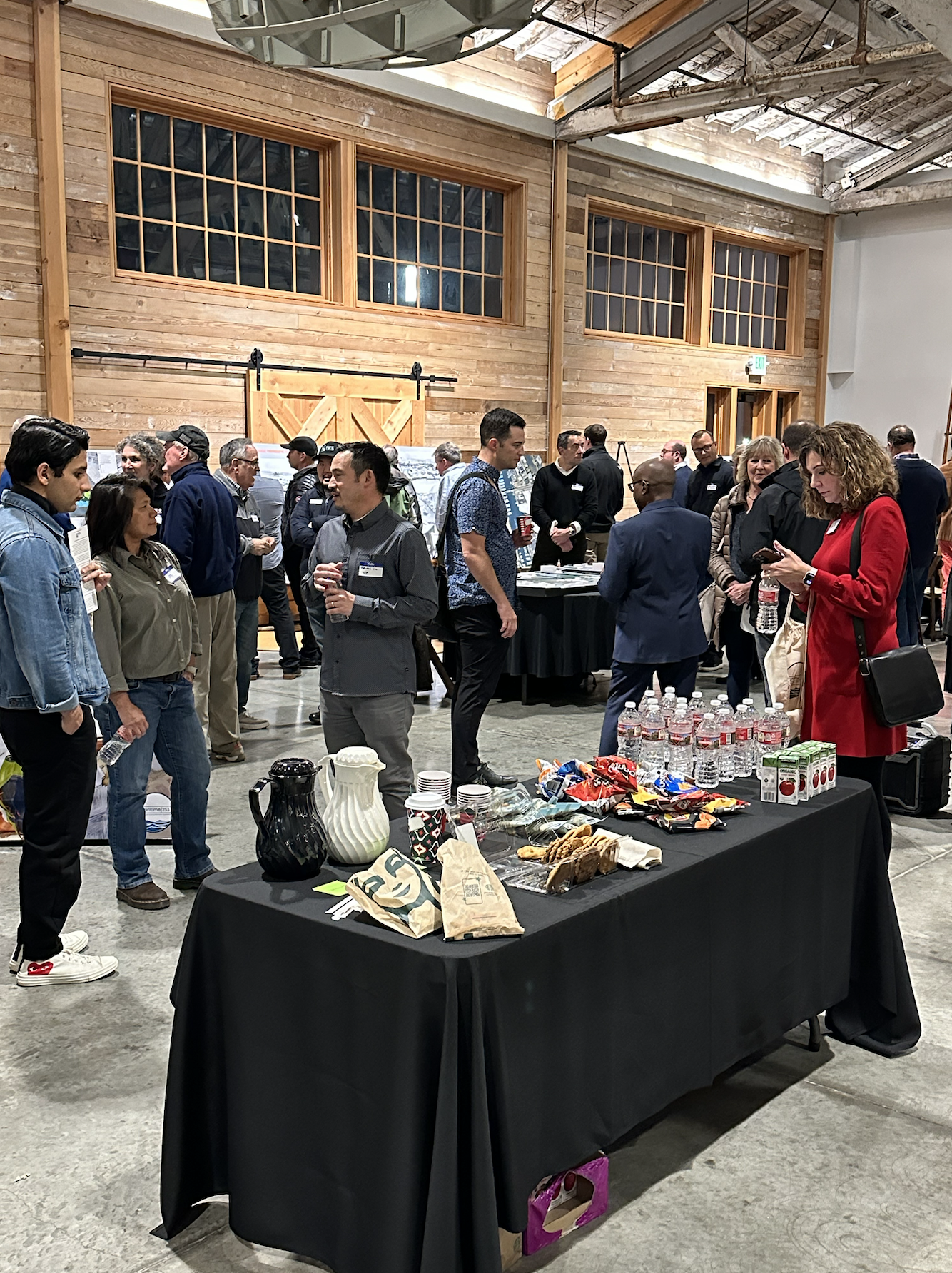 A large group of people are standing at an open house talking
