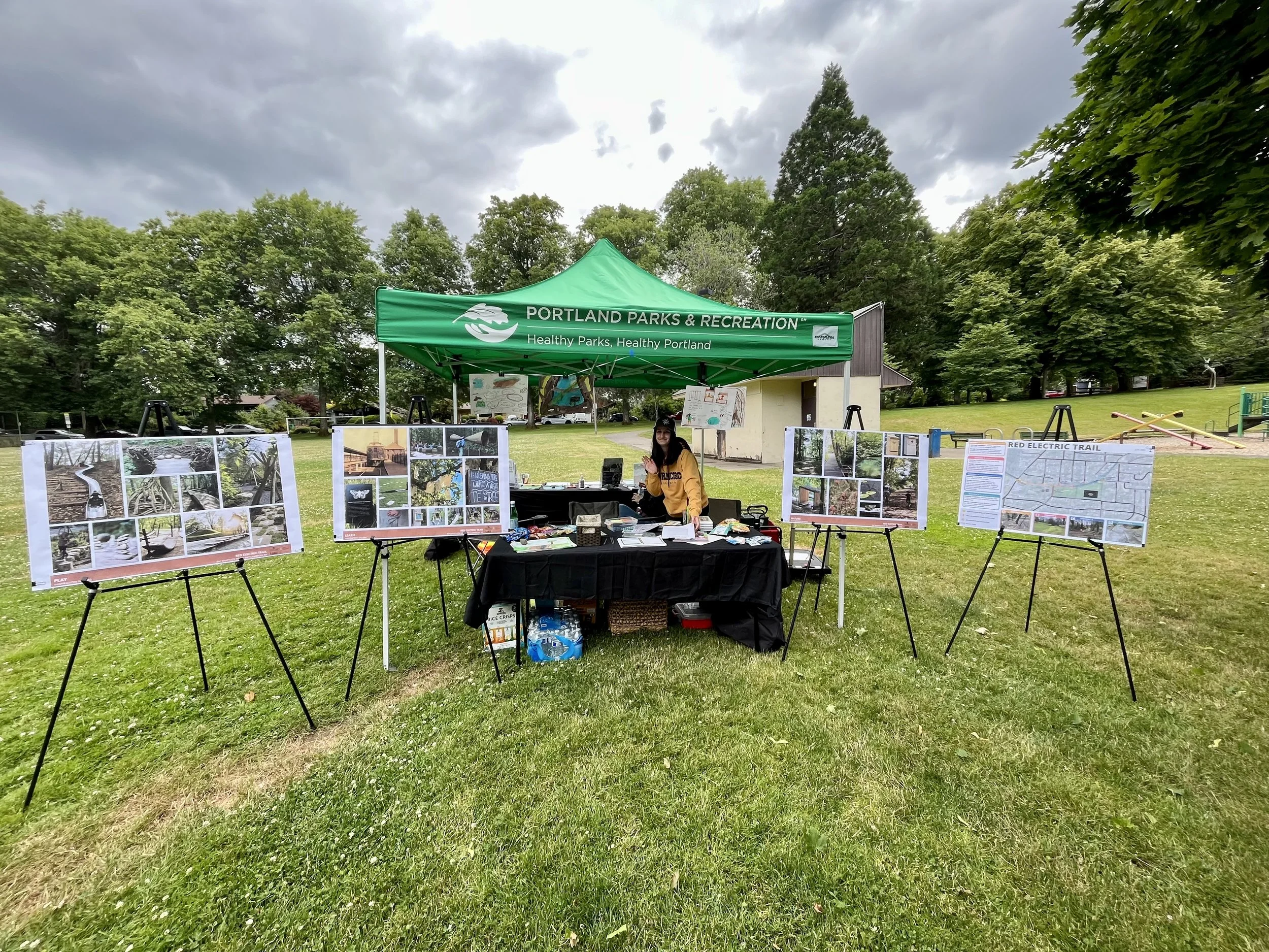 An image shows a girl standing under a tent with poster boards around it