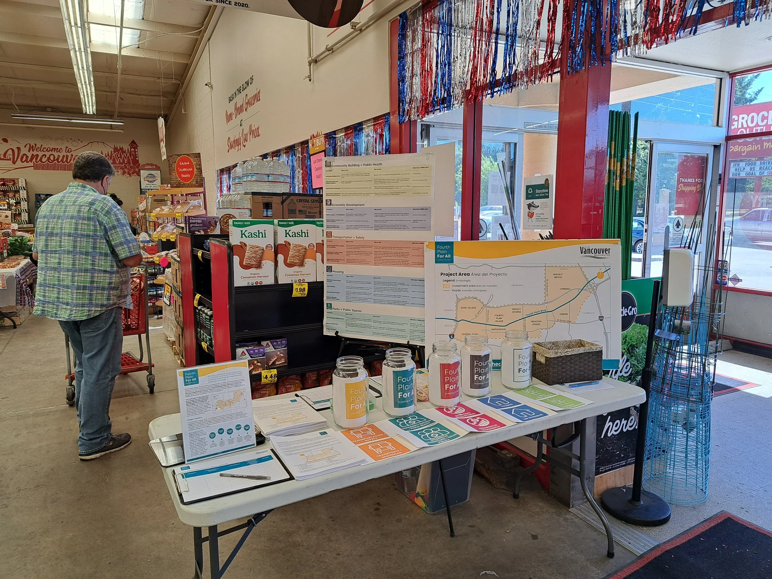 An image of a Fourth Plain for All table set up with display boards and documents at a Grocery Outlet store
