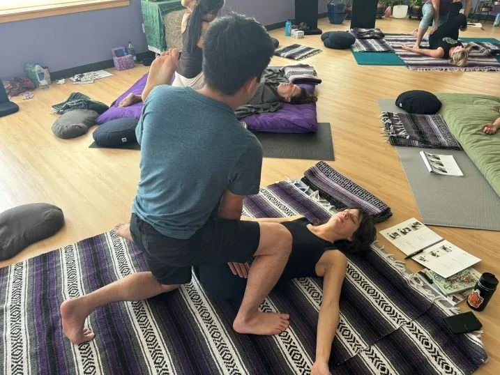 Thai massage folded leg stretch while pressing down the IT bands