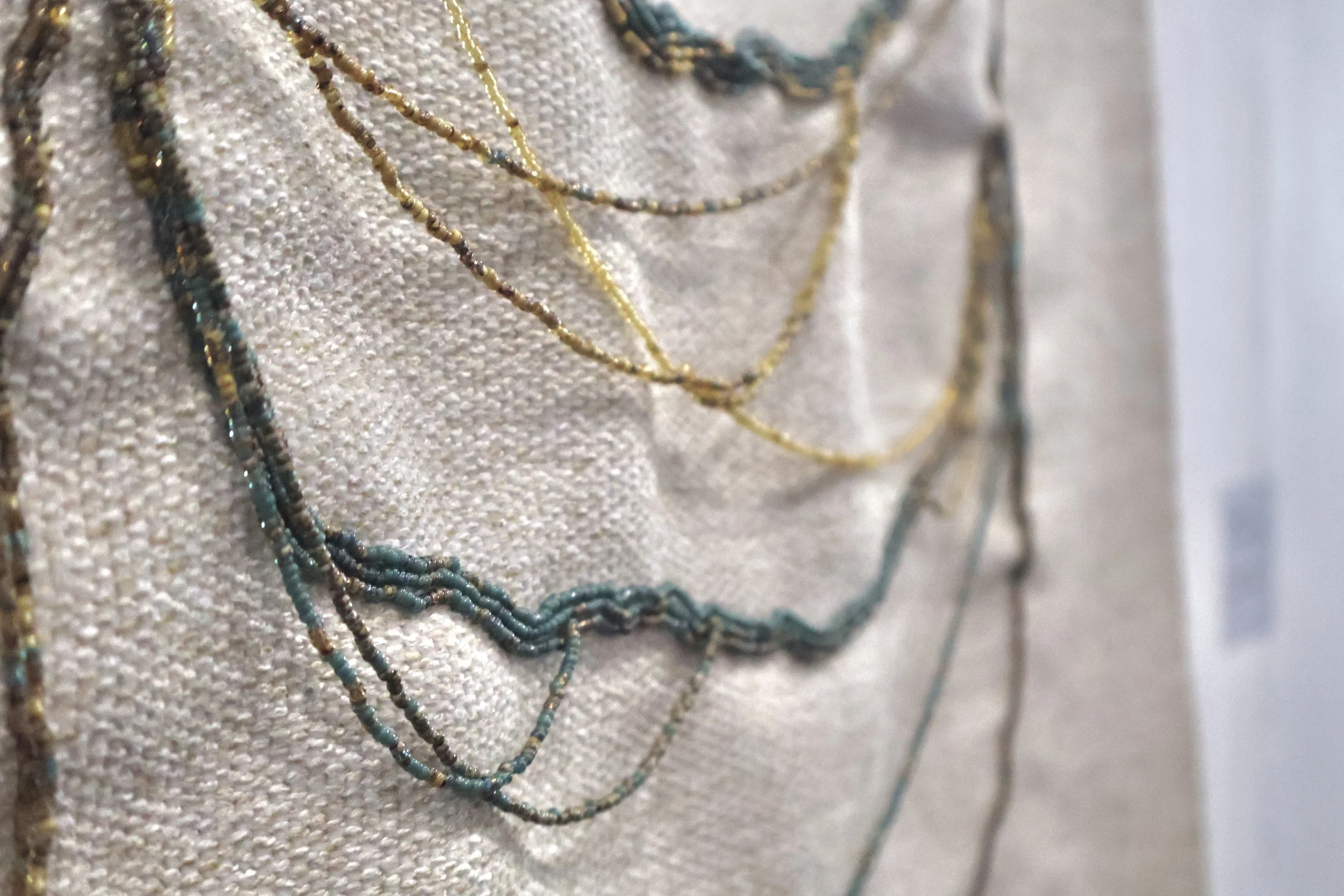 "Residual Effects", 2025, Glass seed beads, Silk thread, Projected digital media, Woven fabric