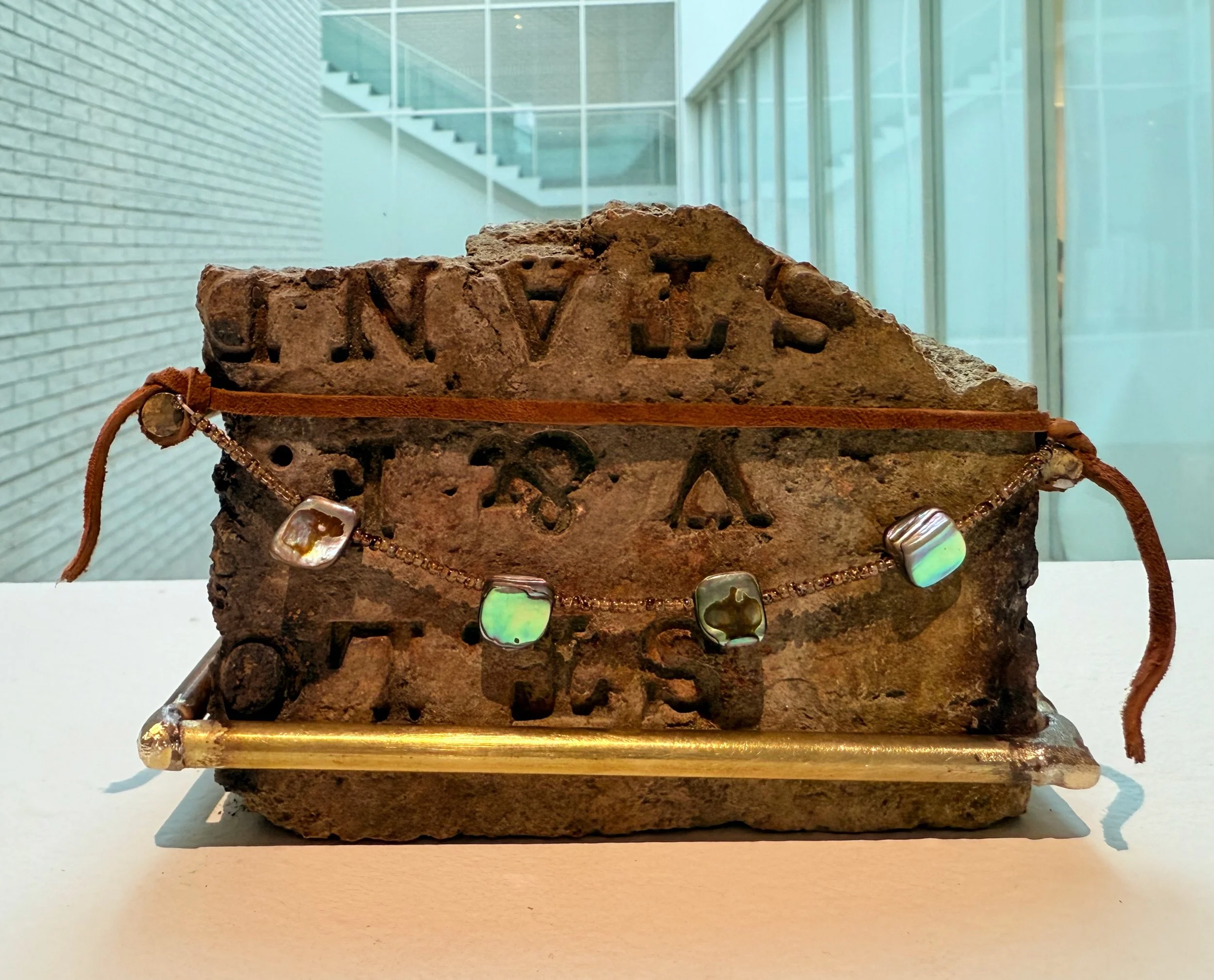 "Words Unspoken", 2025, Abalone, Brazed 
Brass, Found Brick, Glass Seed Beads, Leather