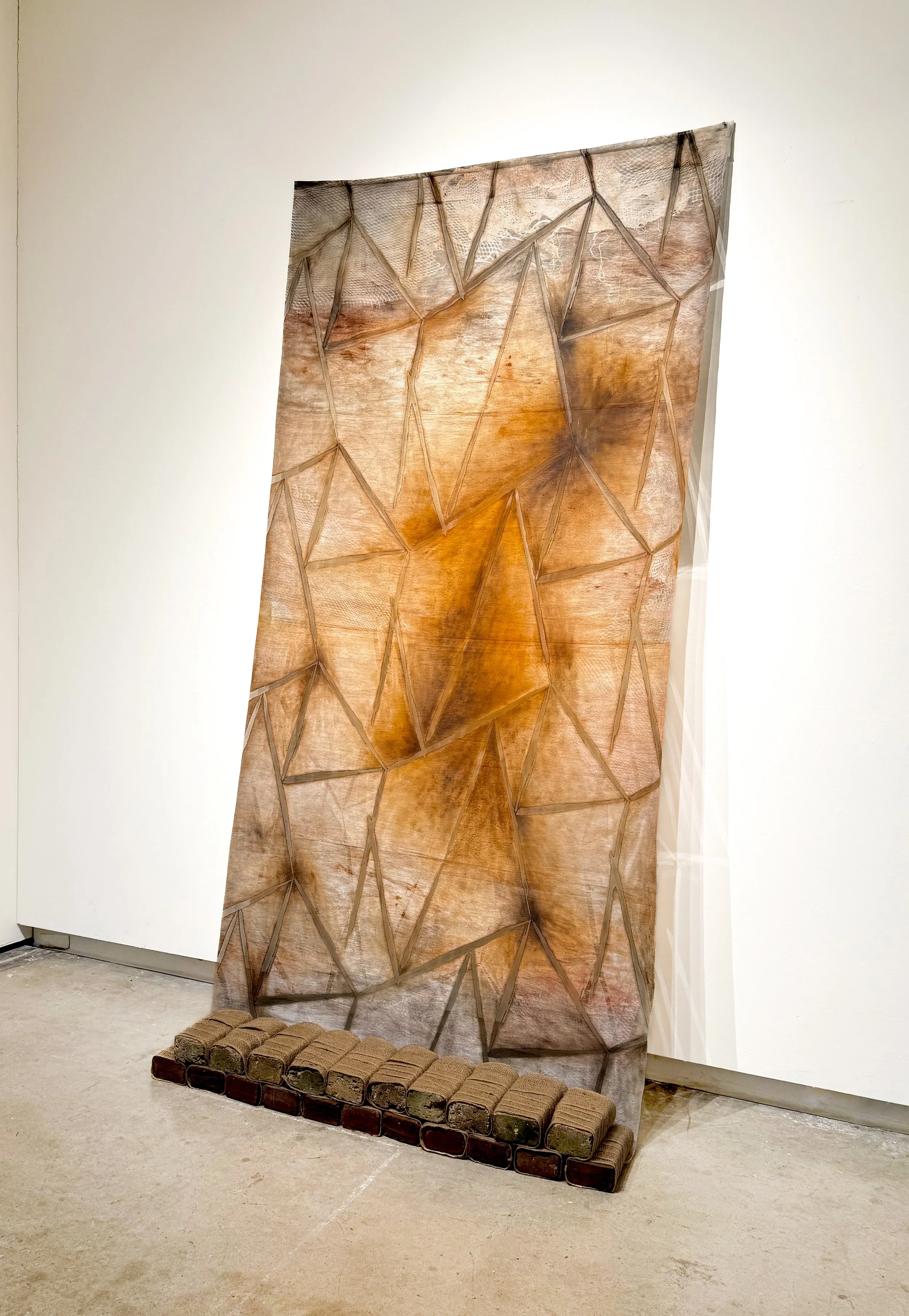 "Desire Paths Land at Crossroads",  2025, Monotyped Relief Ink and Oil on Fabric, Found Bricks, Burlap (40” x 86”) - Collaboration with Evan McHenry