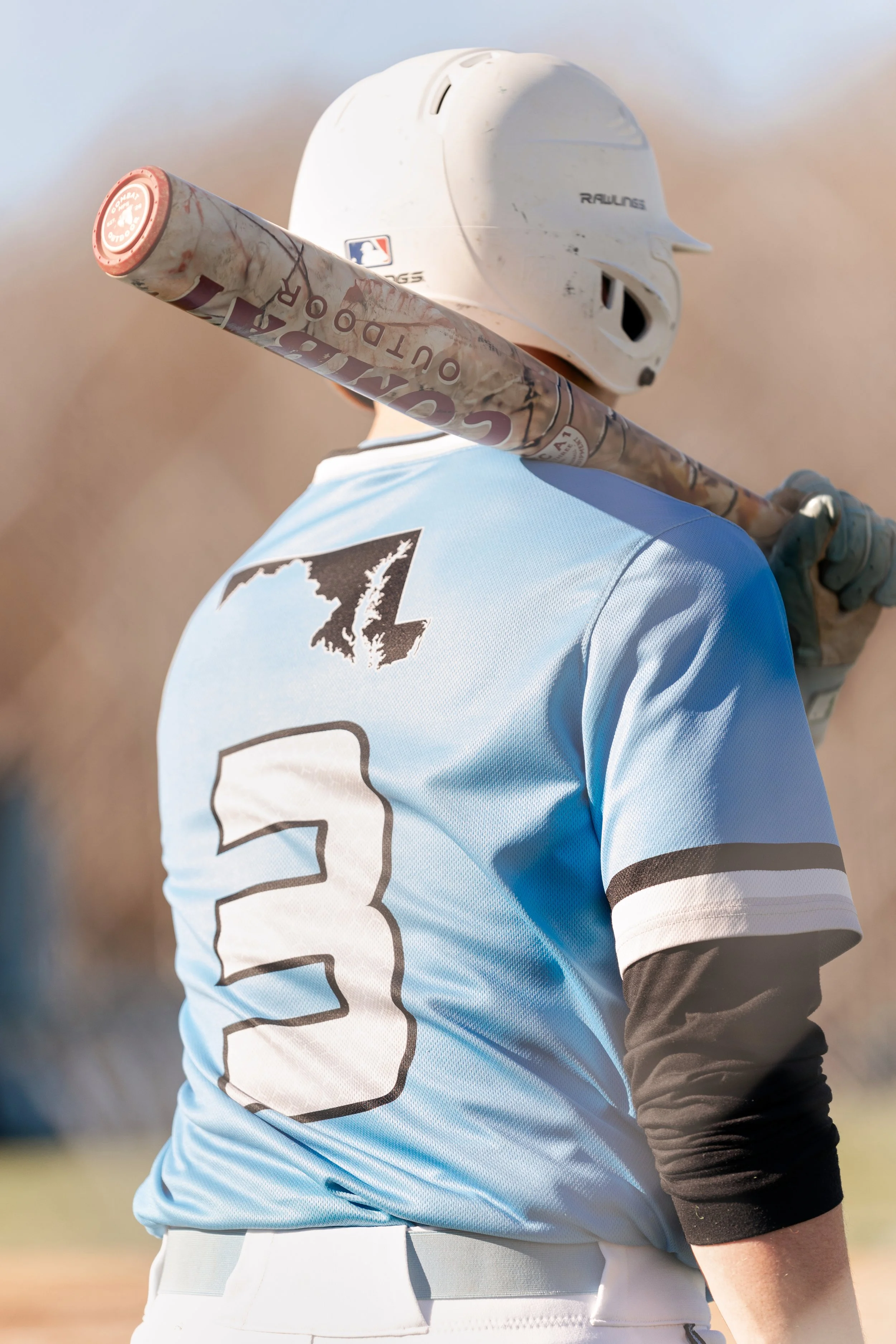 A baseball player wearing a light blue jersey with the number 3 on the back, holding a bat over his shoulder, and wearing a white helmet.