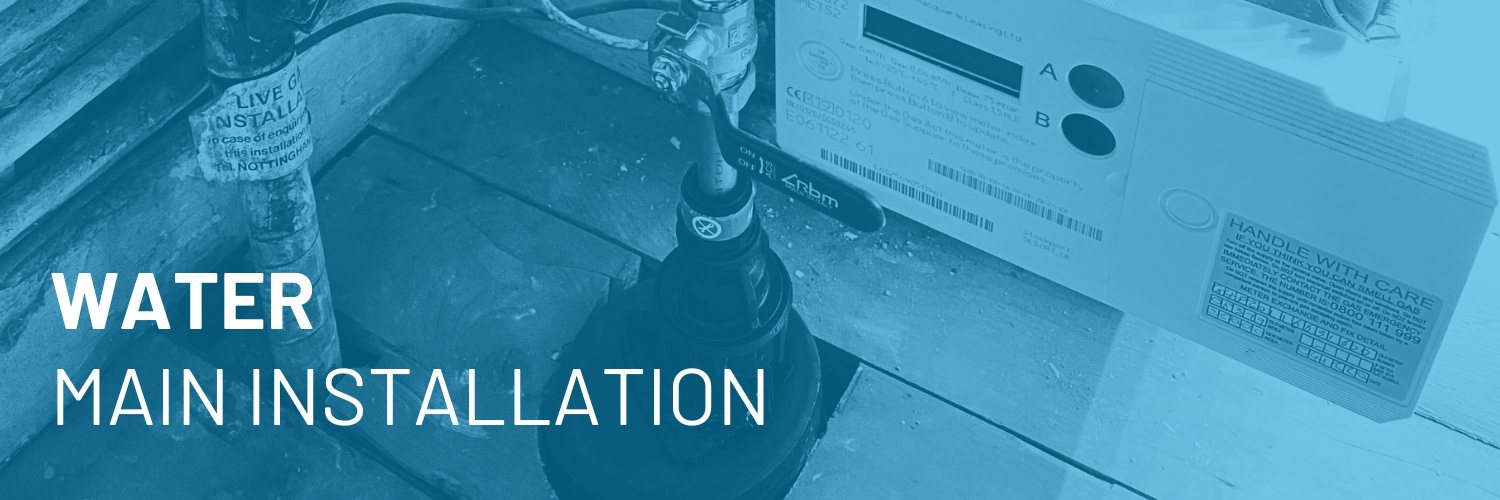 Water main installation at a construction site with a water meter and a valve, surrounded by construction materials and tools.