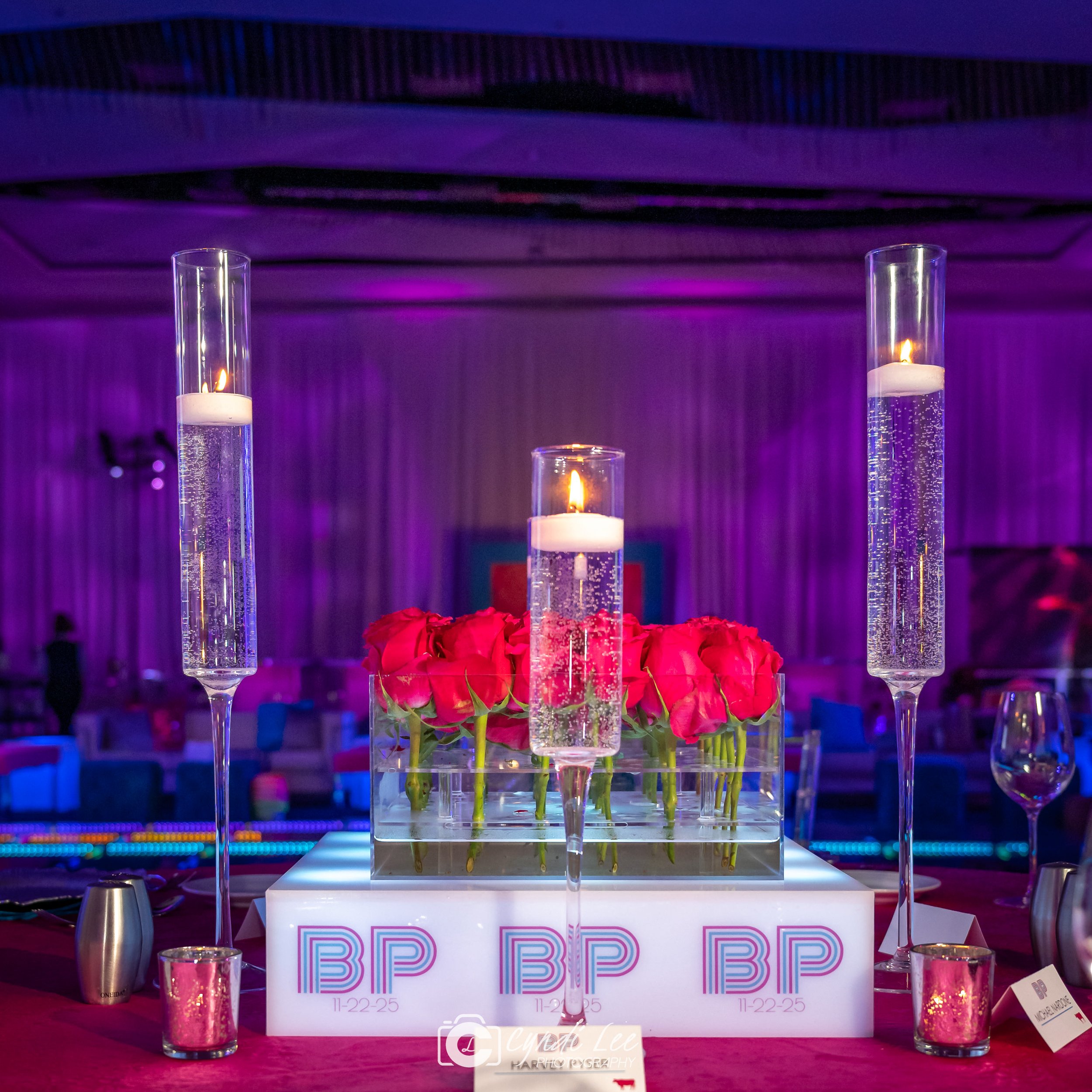white glow base with initials BP on it, three floating candles with pink roses 