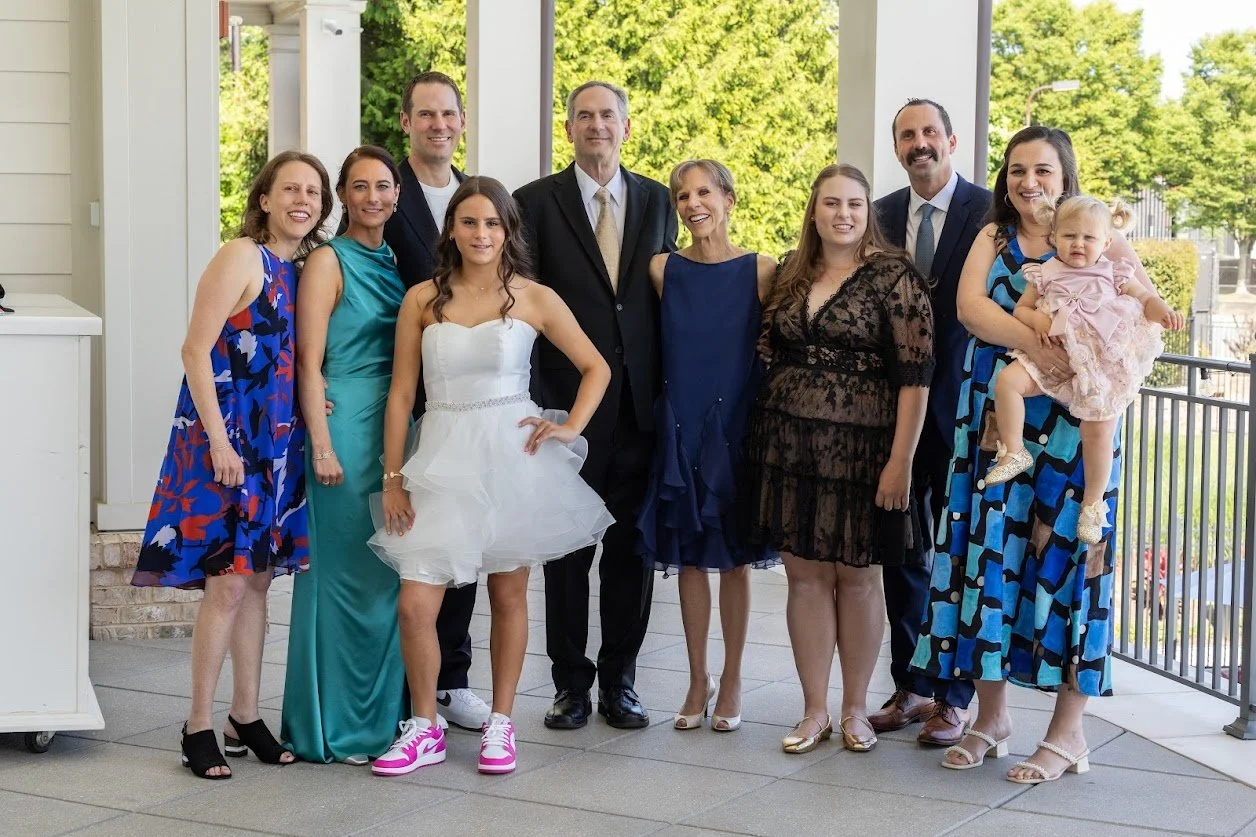 family gathered in formal outfits on an outdoor terrace