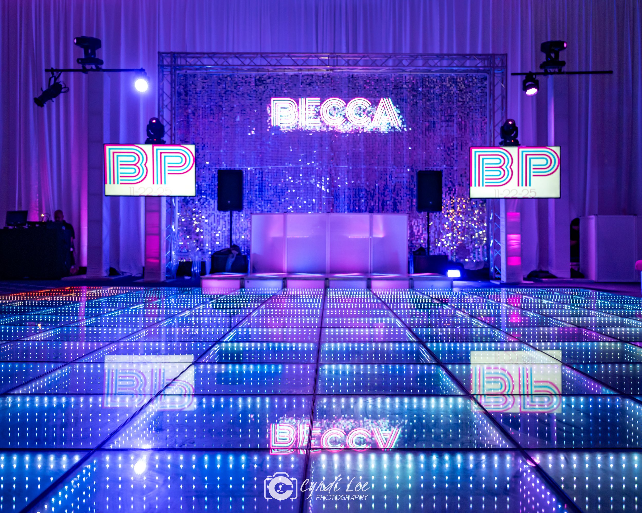 silver shimmer backdrop with neon sign, blue LED dance floor