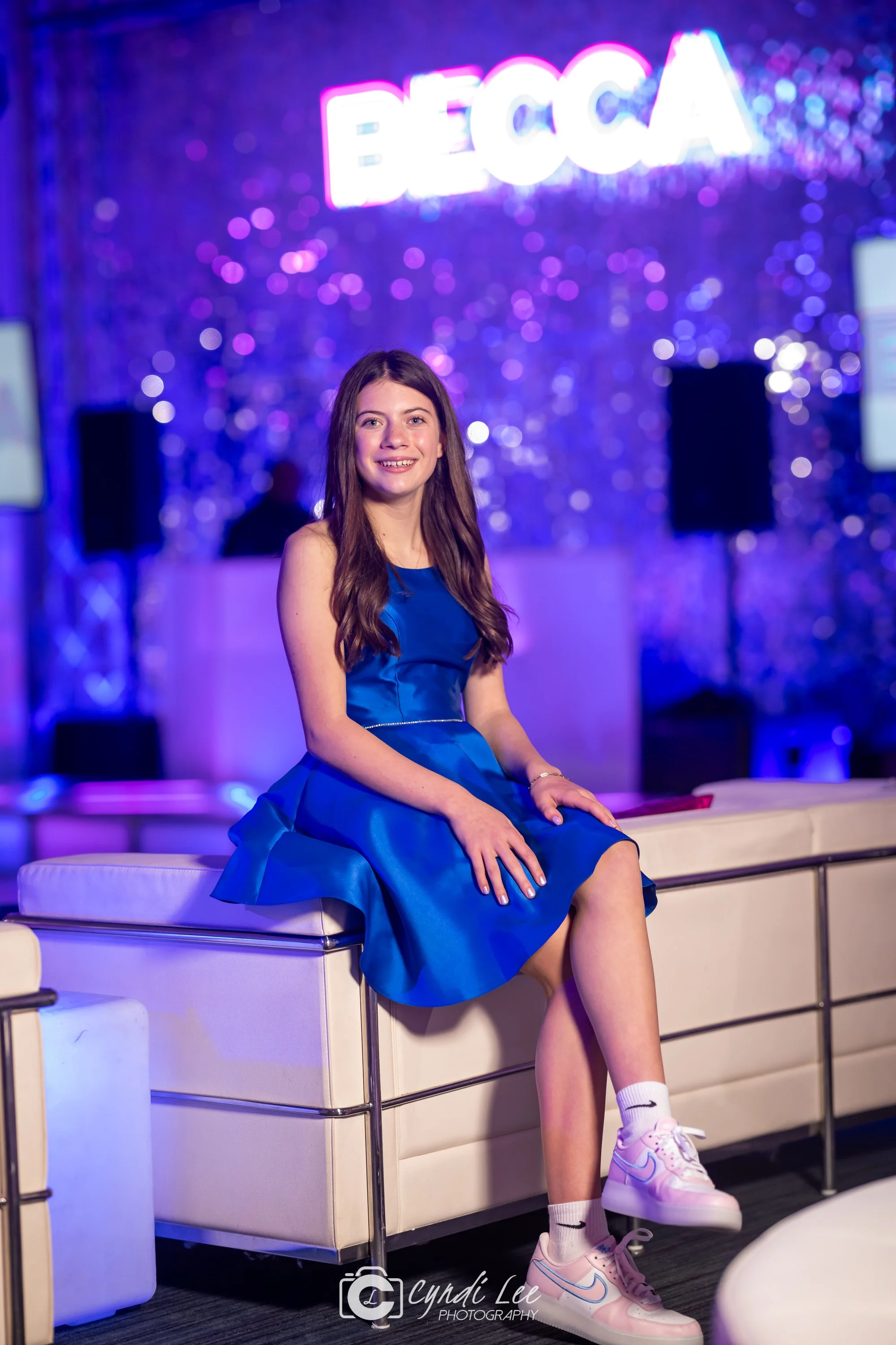girl in blue dress sitting on white couch
