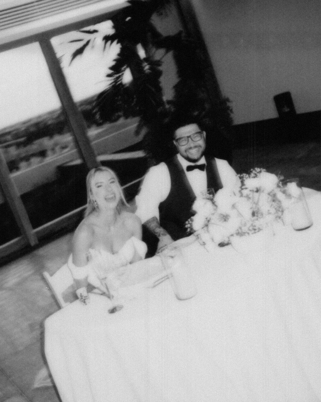 A black-and-white Candid wedding photography of a couple in their reception dinner. Destination Wedding in a rooftop in Playa del Carmen, Secrets Moxche.