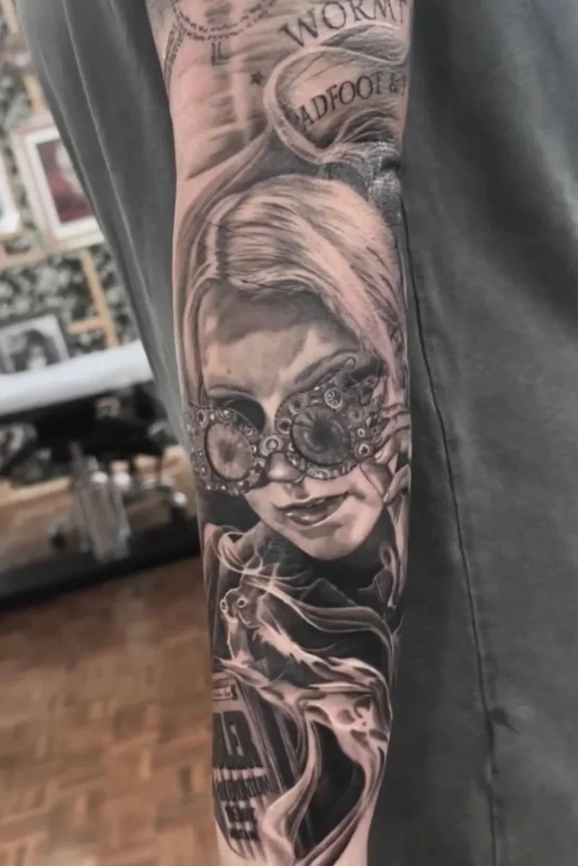 Black and gray tattoo sleeve featuring a woman with goggles, a rat, and car details.