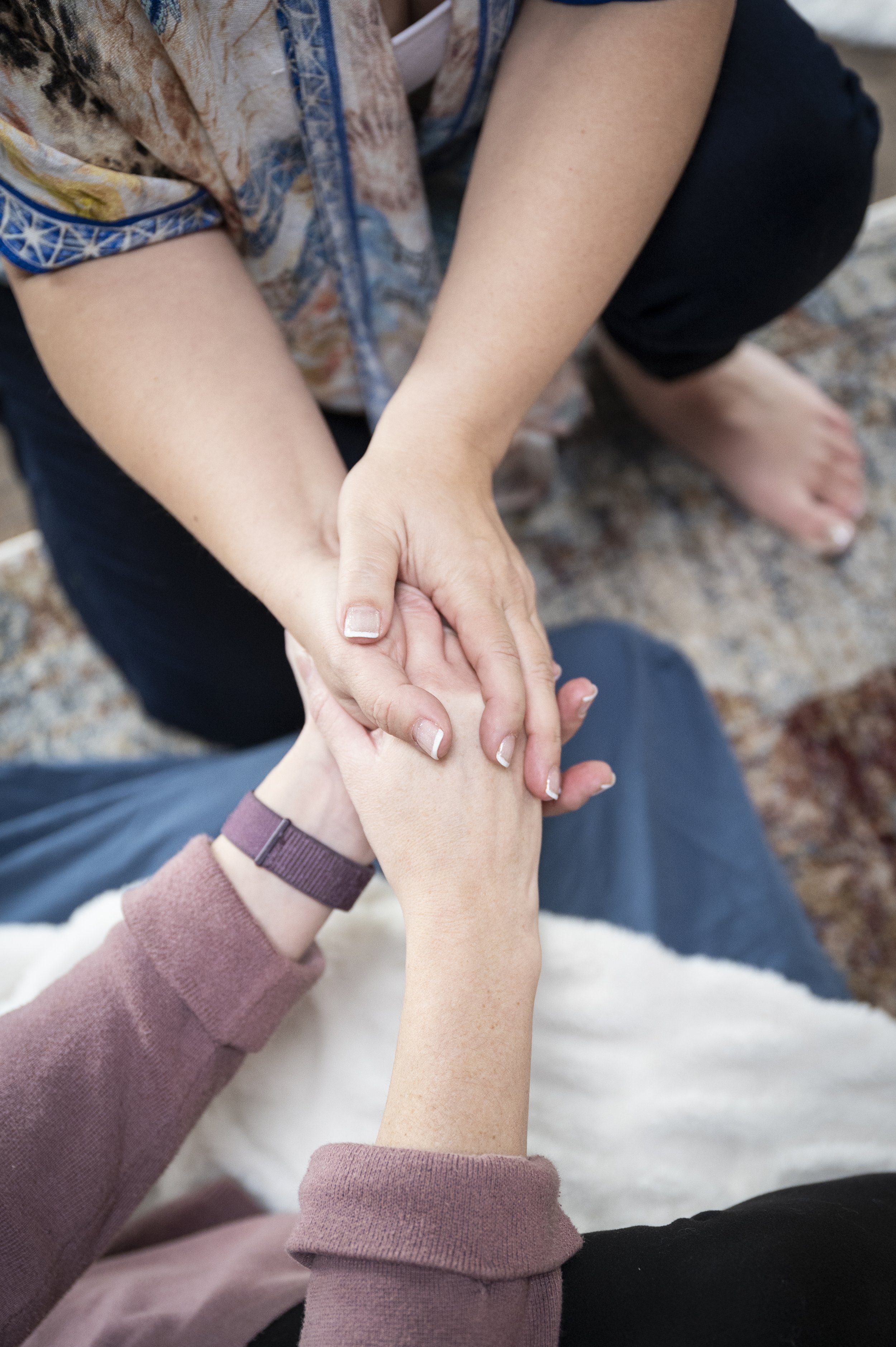 Two people holding hands, offering support during psychedelic preparation