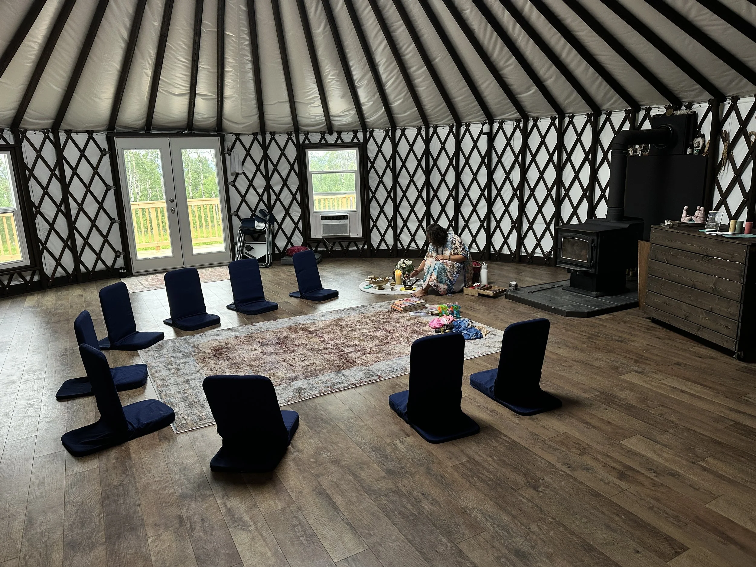 Circle of floor chairs in a yurt, set up for a psychedelic integration circle