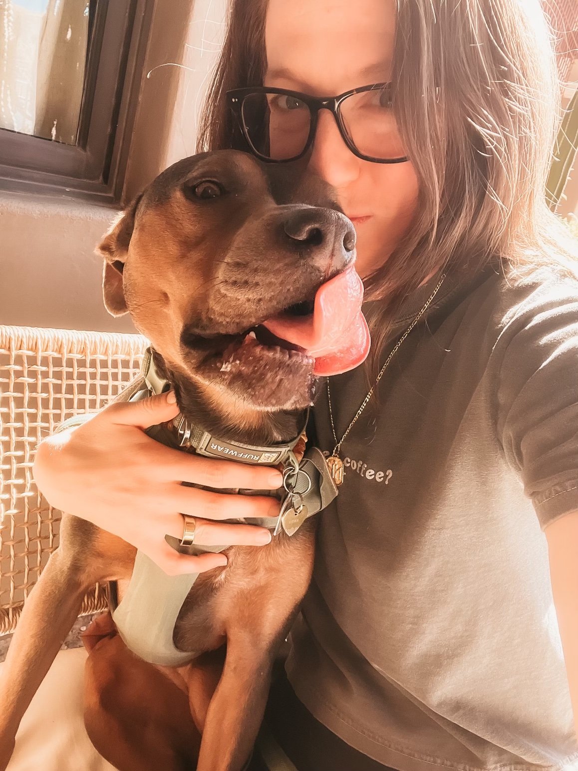 Dr. Elizabeth holding Luna close in warm indoor sunlight, illustrating nervous system protection and co-regulation in a blog about why symptoms repeat during healing.