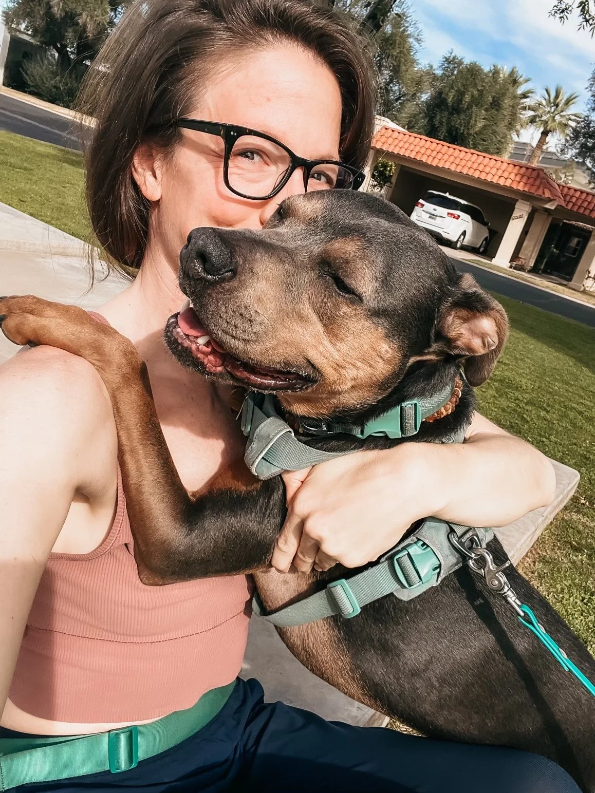 Dr. Elizabeth hugging her dog Luna outdoors, reflecting the calm connection and safety that support nervous system regulation.