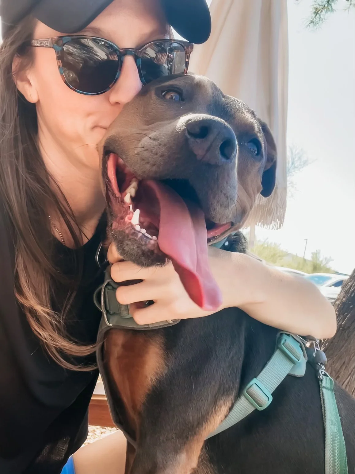 Woman hugging her dog outdoors, representing nervous system safety, clarity, and emotional regulation