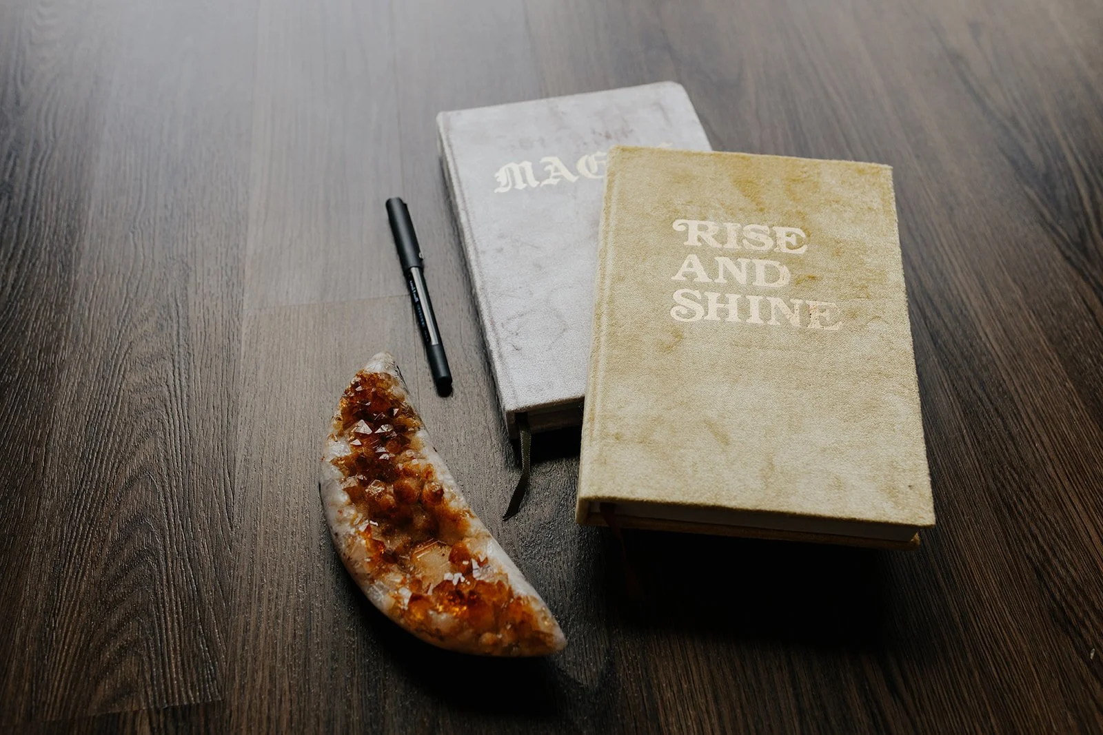 Journals, pen, and crystal placed intentionally on a table, representing nervous system regulation, intentional rest, self-reflection, and grounded healing practices