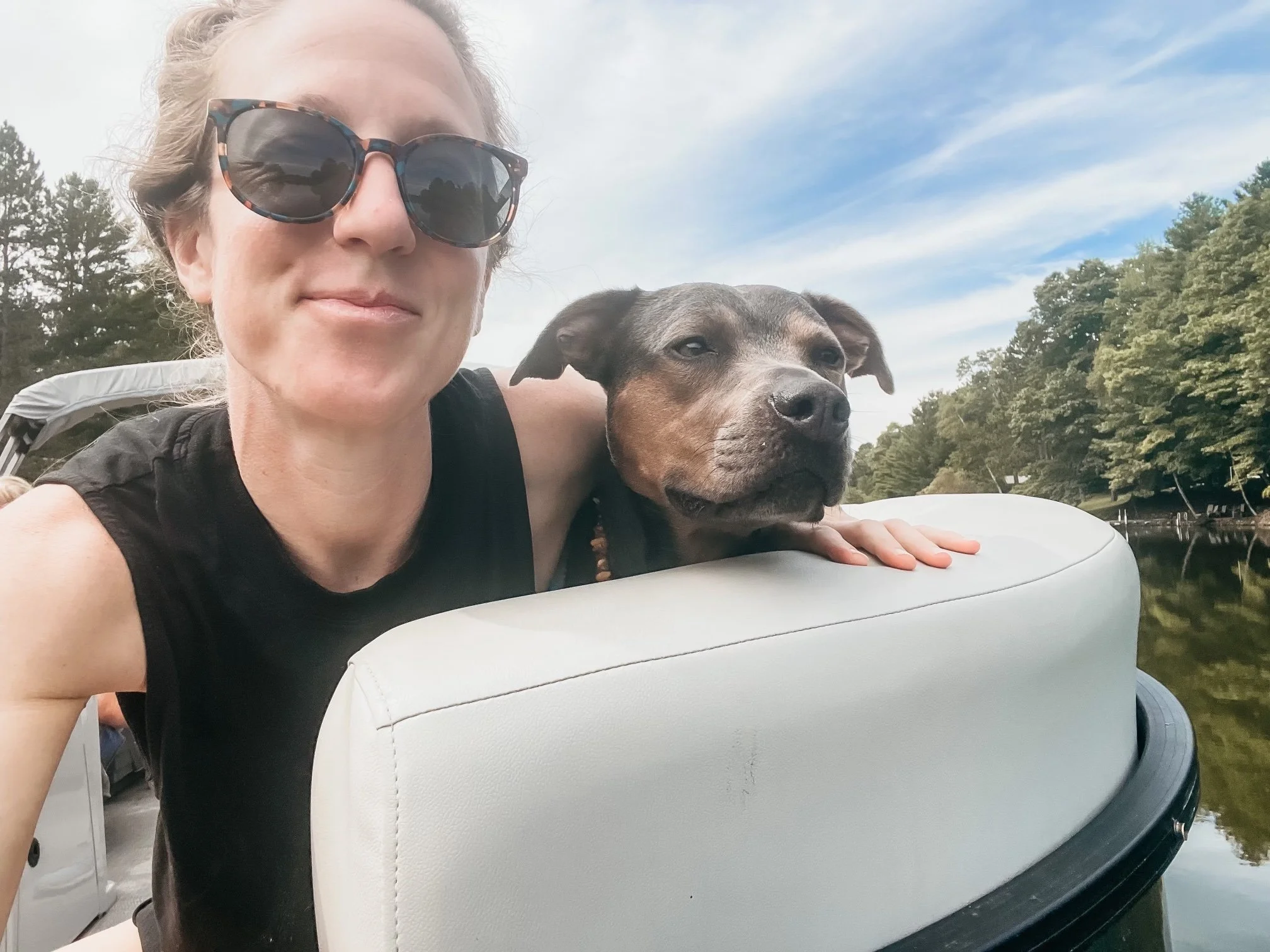 Dr. Elizabeth  relaxing with her dog on a boat during a peaceful lake day.