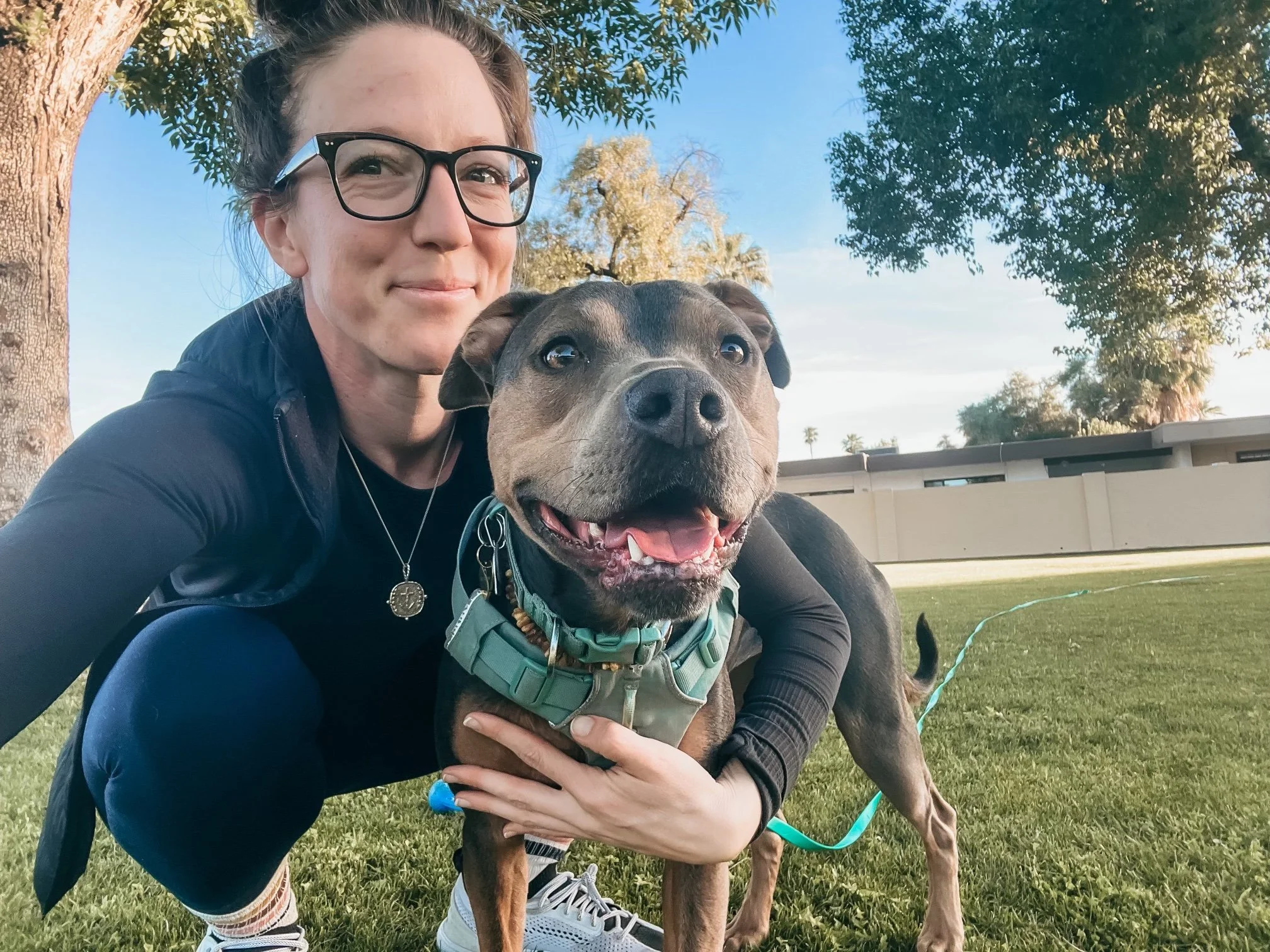 Dr. Elizabeth sitting on the grass with her dog Luna after a hike, representing nervous system integration and the quiet progress that happens during healing.
