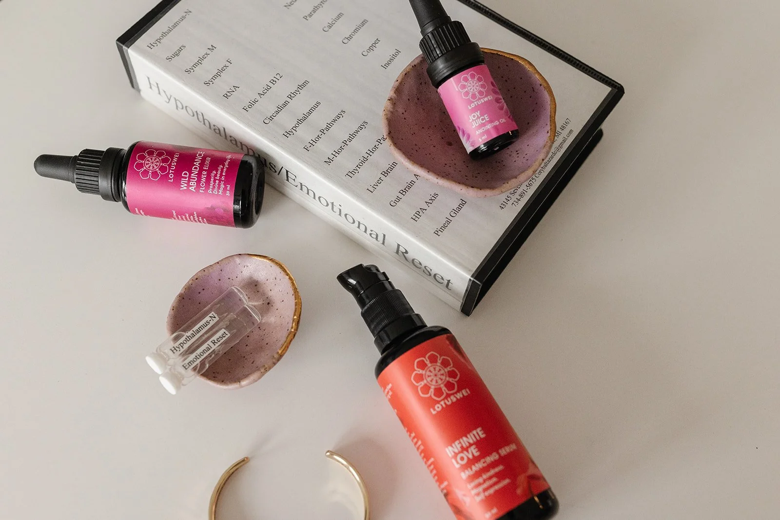 Flower essence bottles and energetic test materials arranged on a surface, representing preventative energy healing, nervous system support, and energetic regulation.