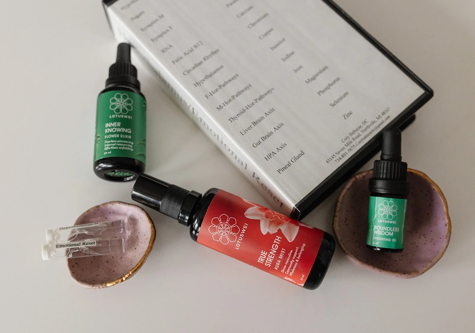 Flower essence mist, elixir, and anointing oil arranged on a neutral surface, representing intuitive energetic support and daily flower essence use.