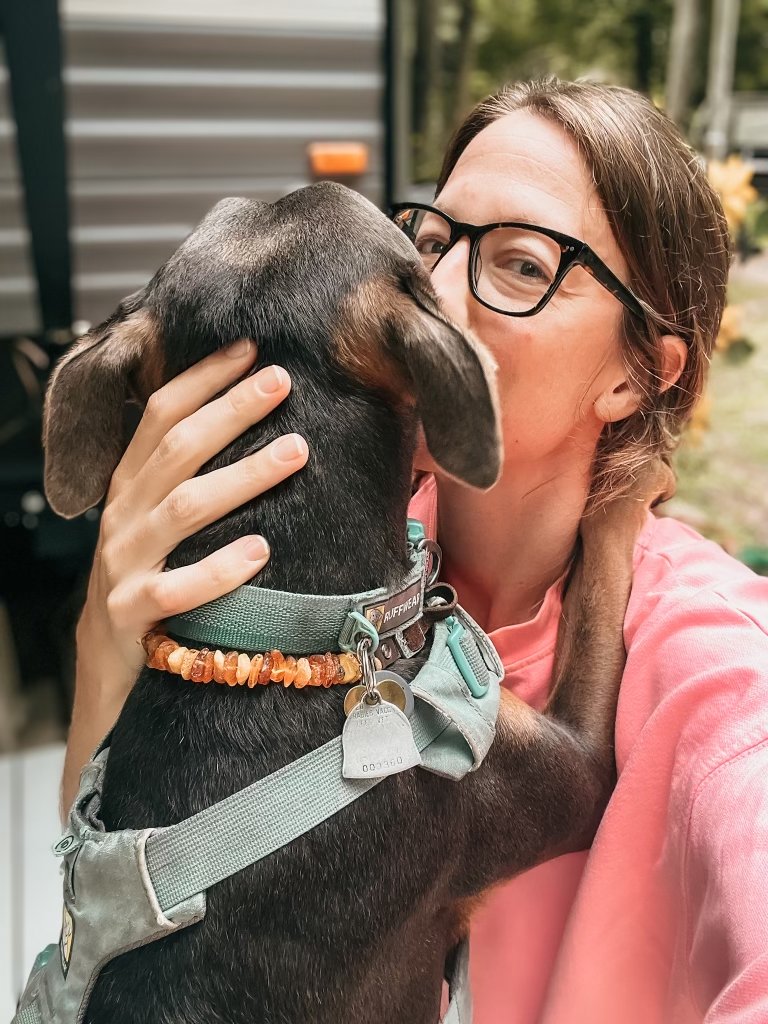 Dr. Elizabeth with Luna outdoors, featured in a blog about persistent headaches, nervous system support, and intuitive healing.