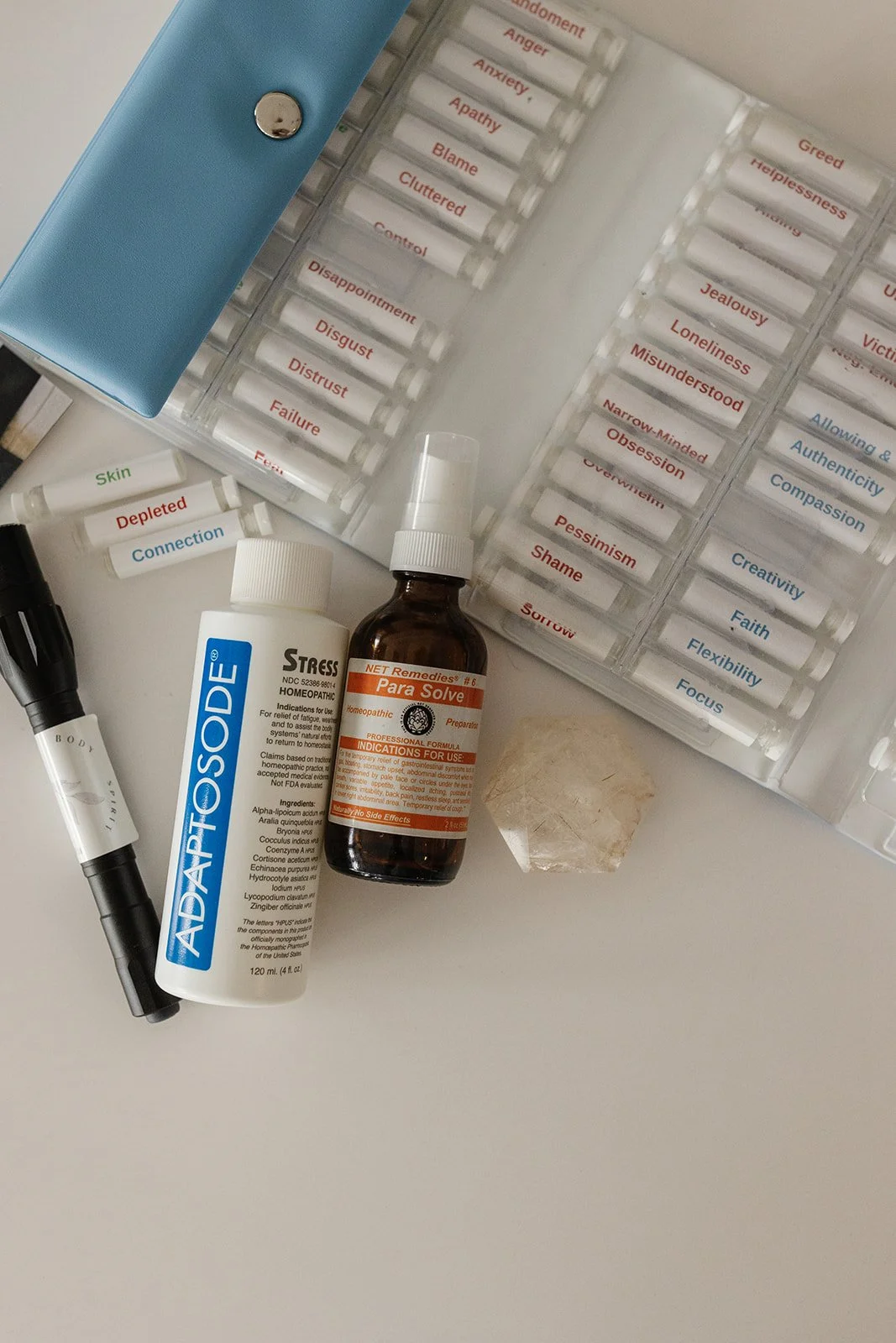Energetic healing tools including homeopathic remedies, flower essences, and testing kits used to support nervous system regulation and energetic coherence.