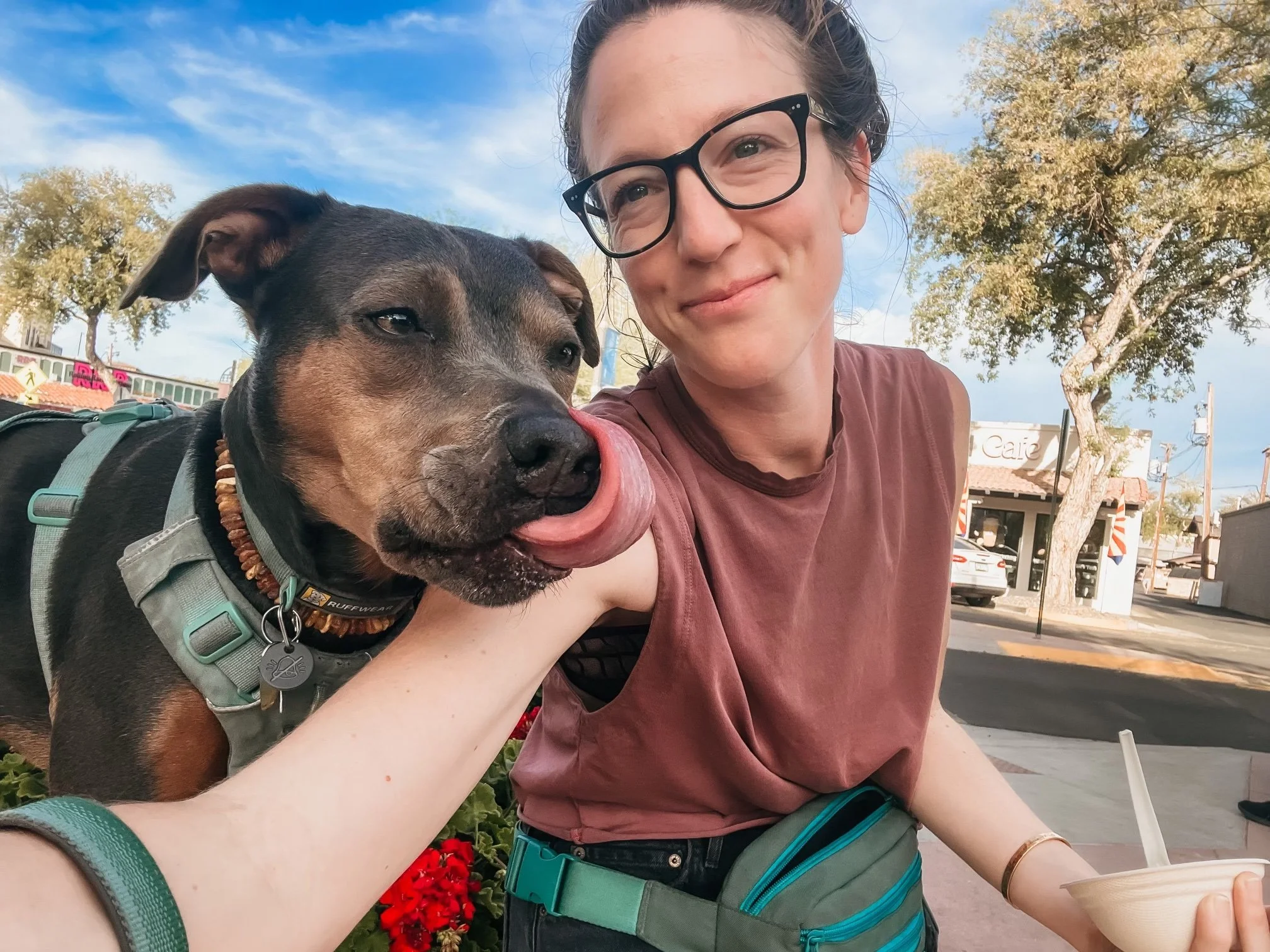 Woman sitting outdoors with her dog, reflecting grounded support, relationship, and deeper healing work