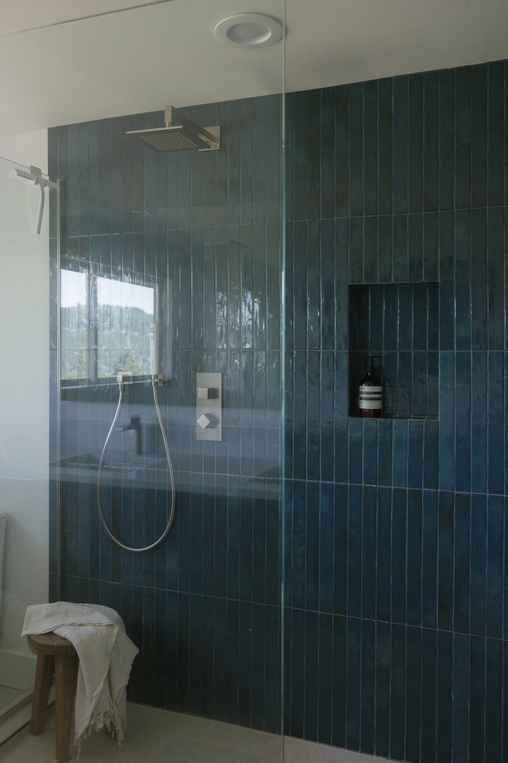 Walk-in shower in vertical stacked blue tile with a glass panel, Hood River bathroom remodel