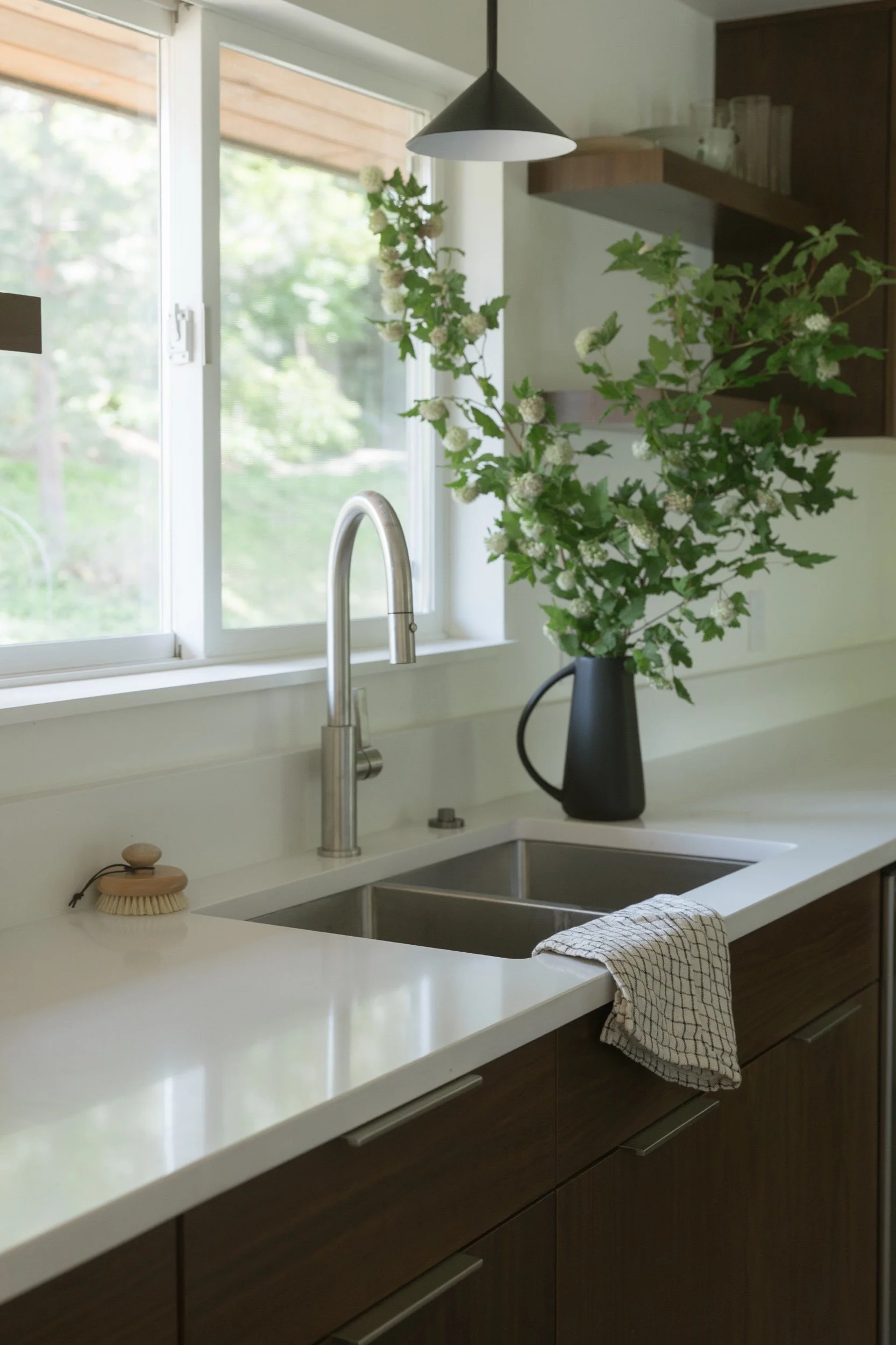 Quartz counters and an undermount sink under the window, galley kitchen remodel