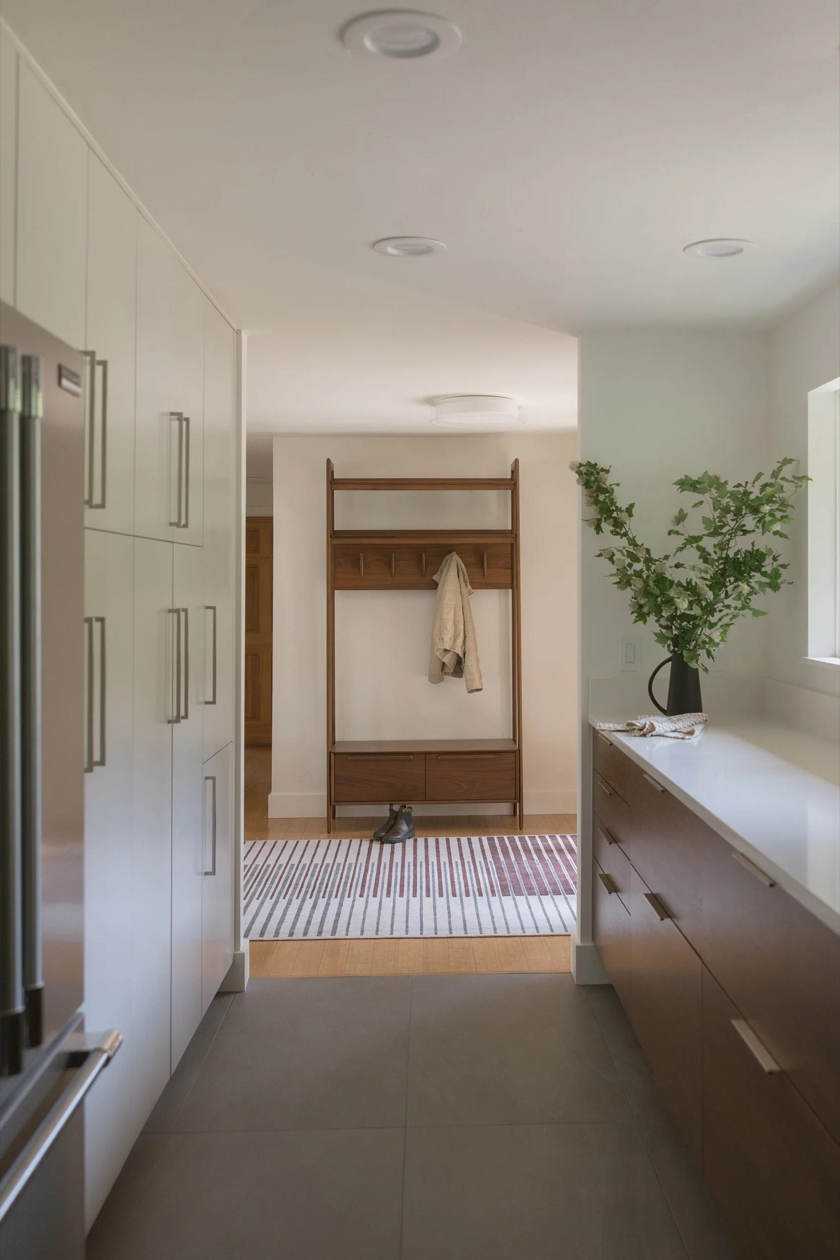 Galley kitchen looking toward the entry, with a full-height pantry wall