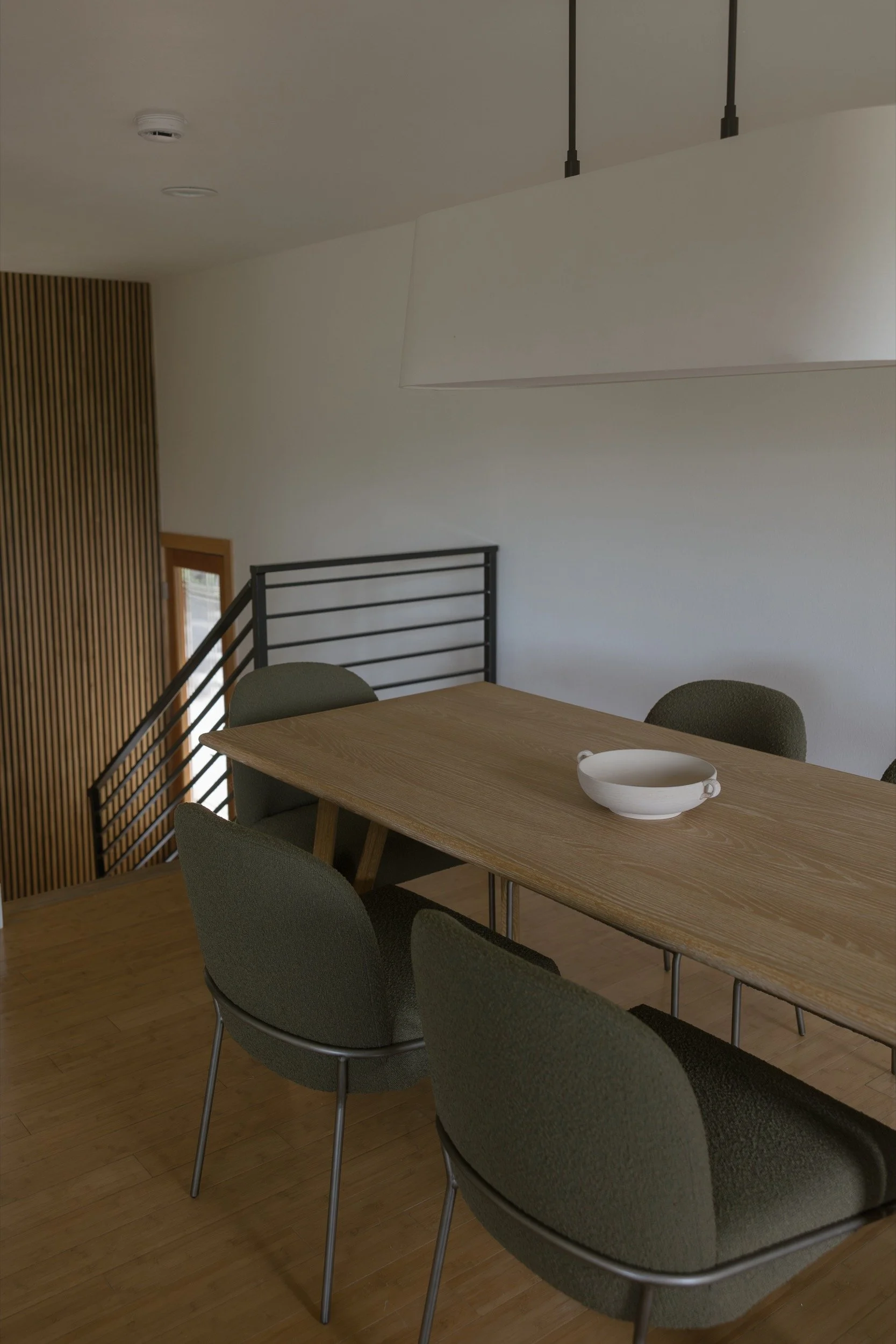 Dining table by the stair with a modern metal railing, Hood River remodel