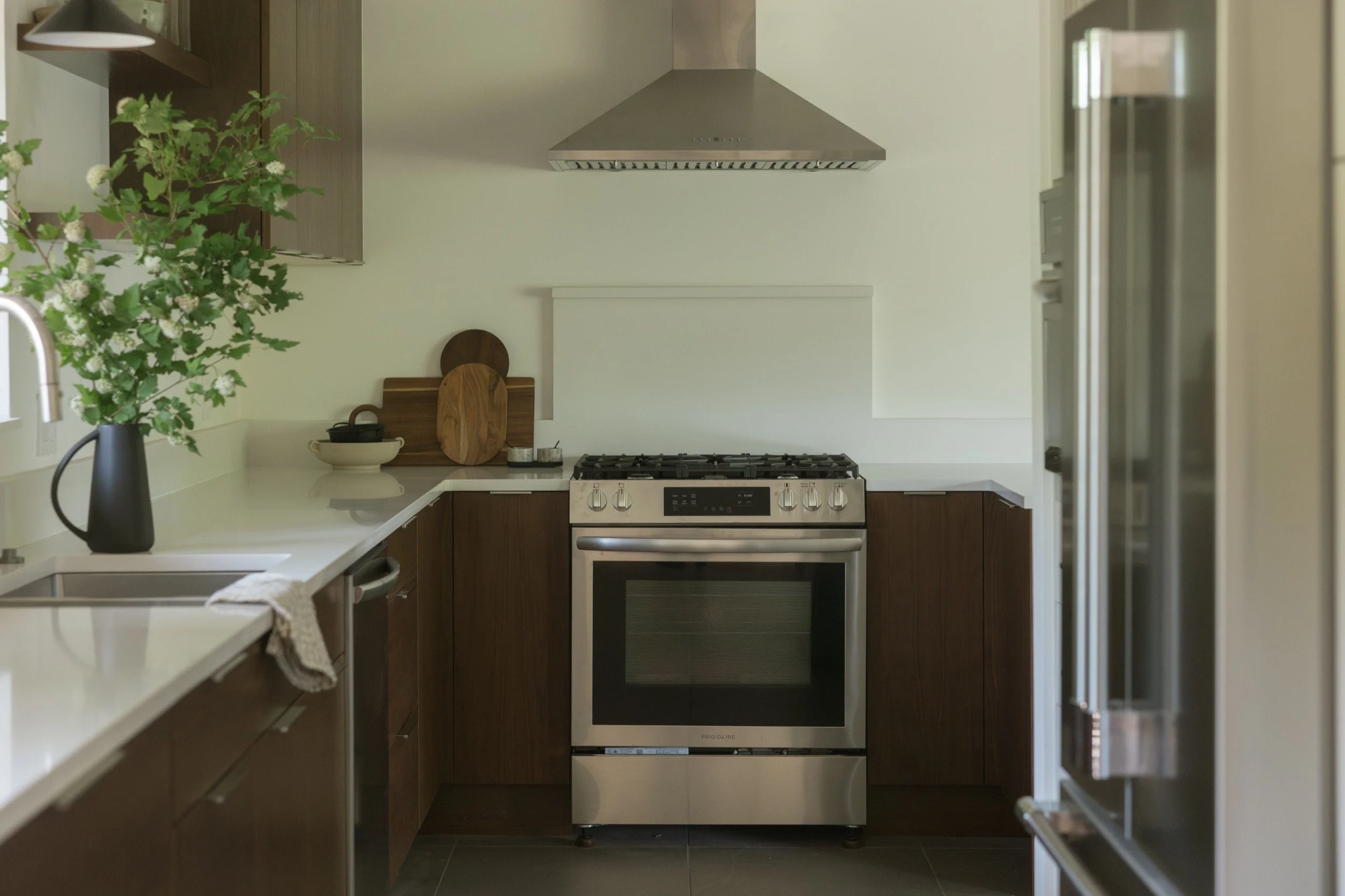 Walnut cabinets, gas range and stainless hood in a Hood River galley kitchen