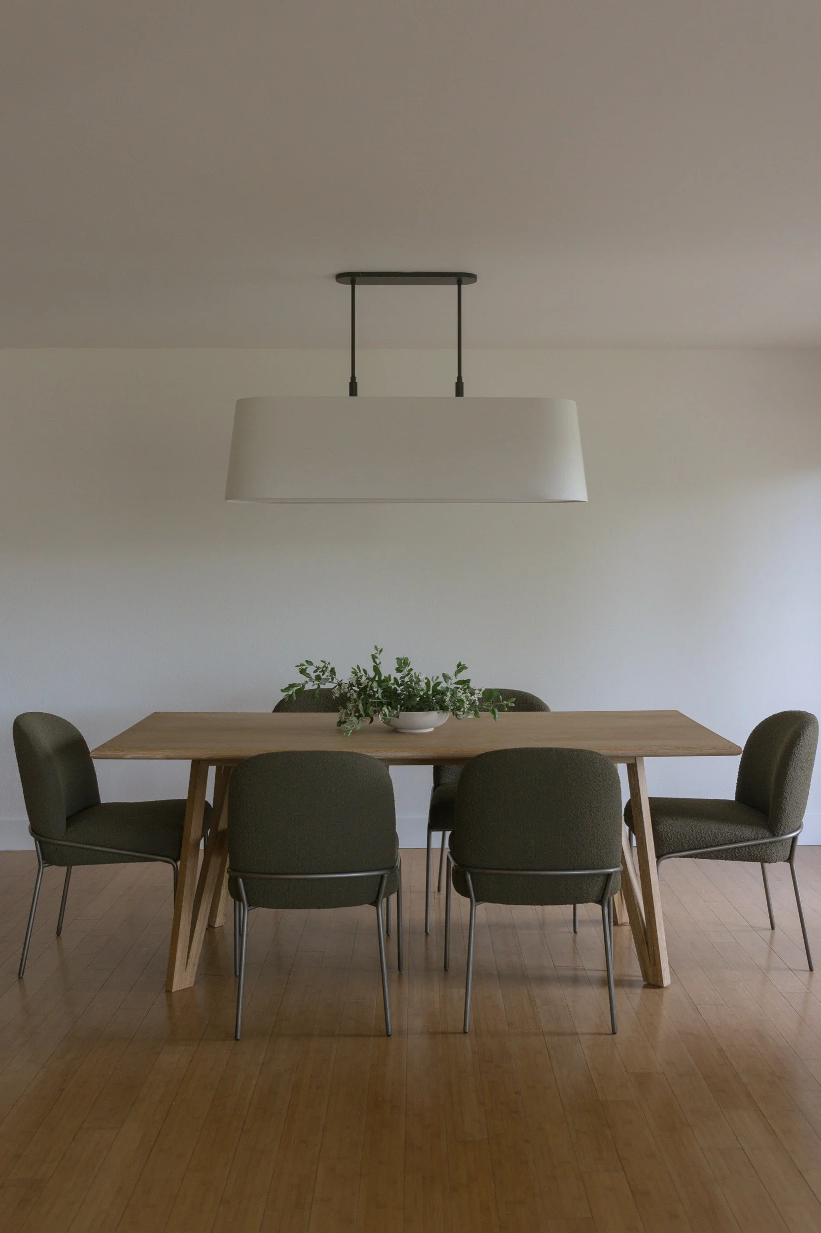 Dining room with a wood table and linen pendant in a remodeled Hood River home