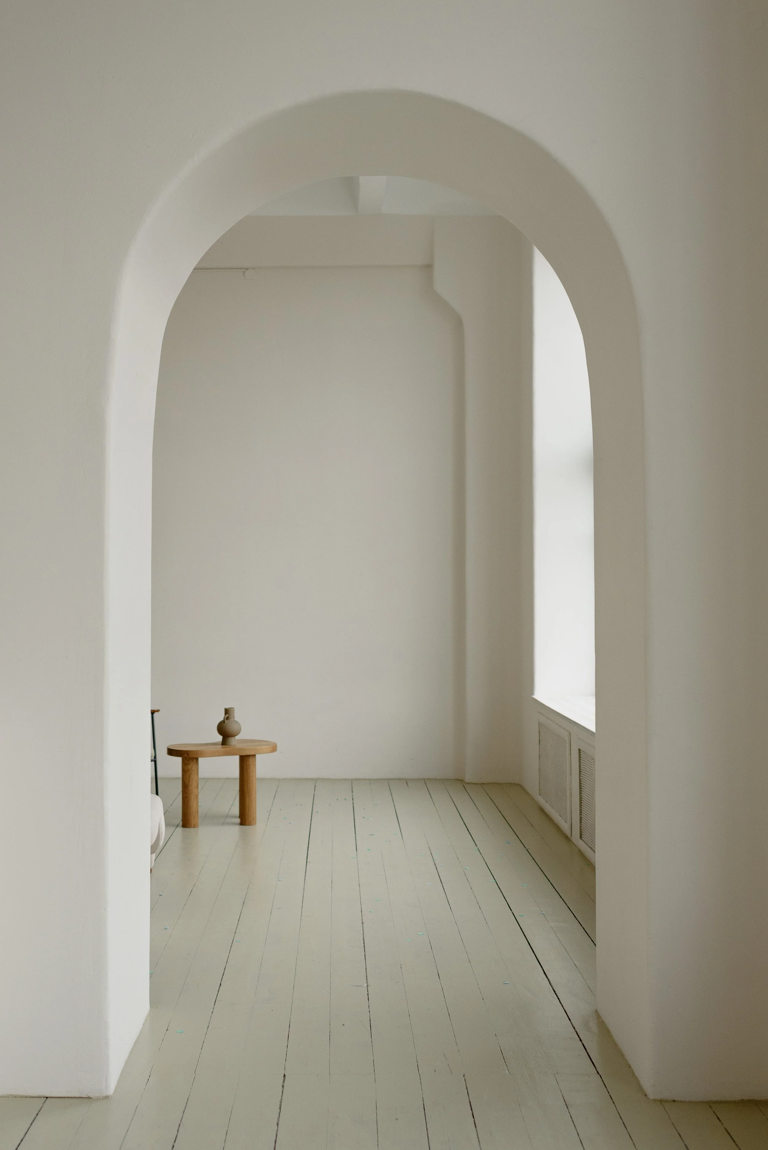 Minimalist room with archway and small wooden table