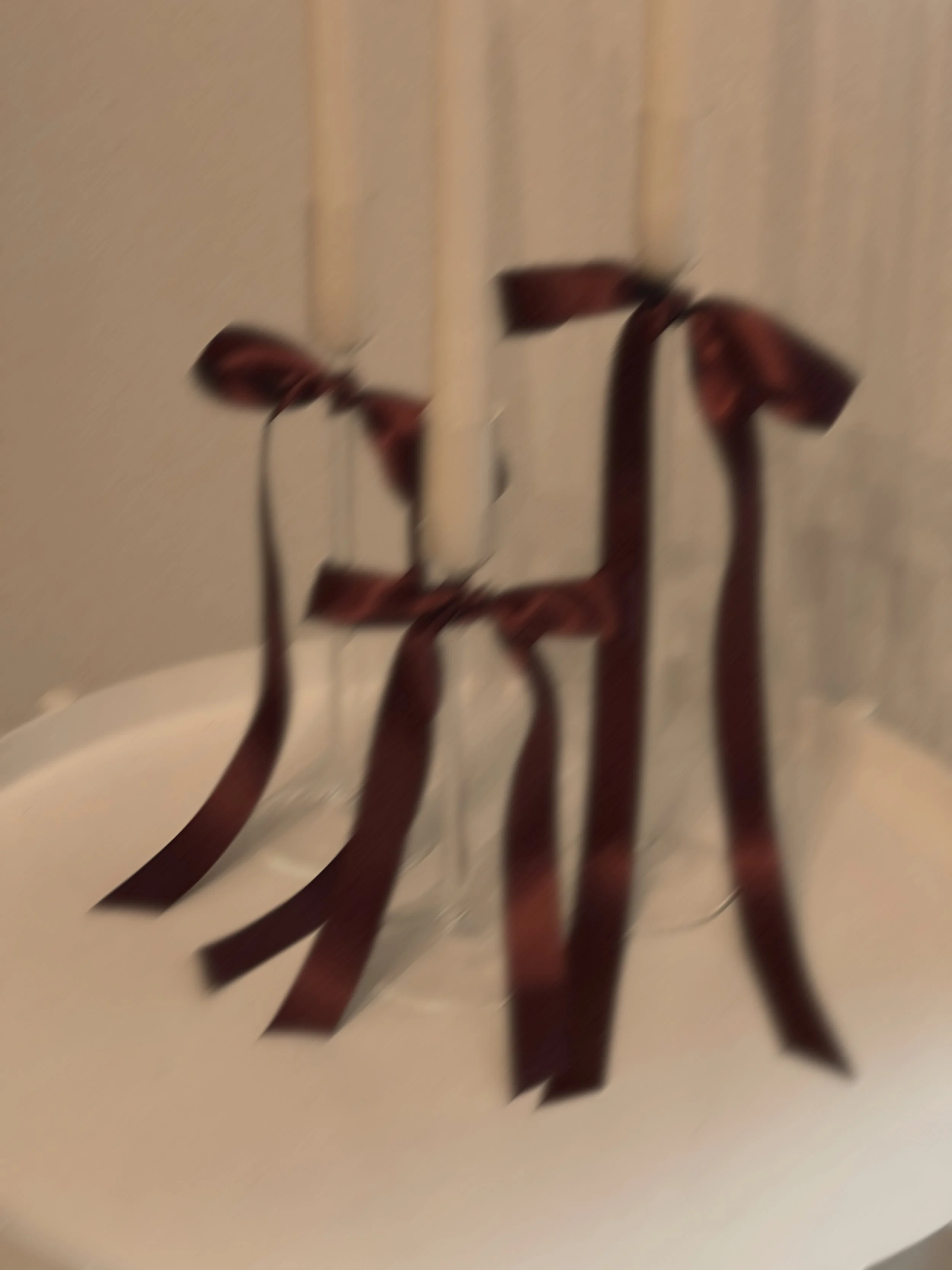 Blurred candles tied with dark brown ribbons