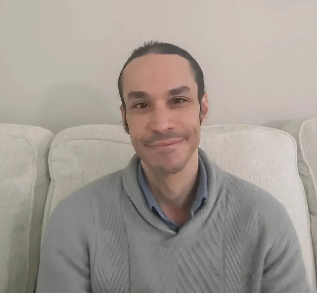 An adult  male sitting on a sofa