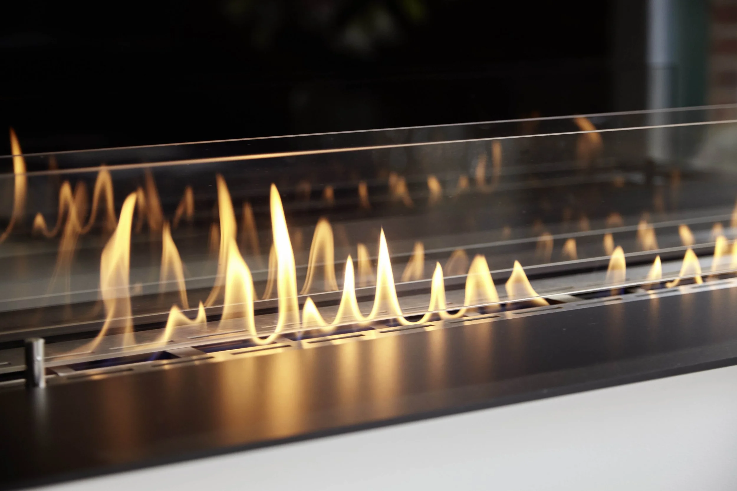 Close-up of a glass-enclosed gas fireplace with flickering flames.