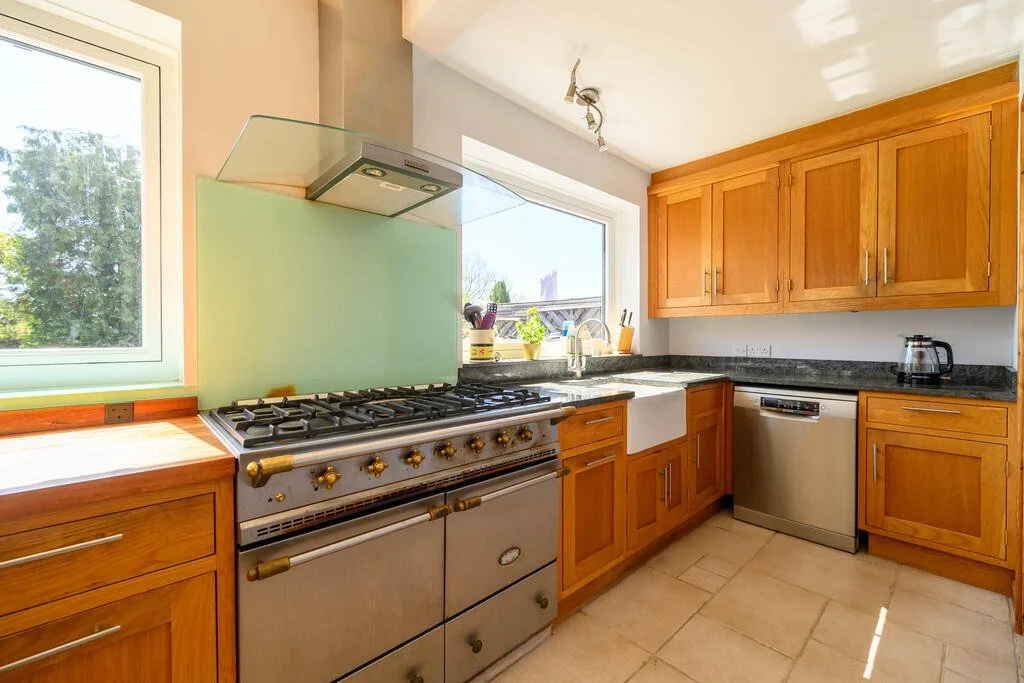 Kitchen with wooden cabinets, a gas stove, a window above the sink, and a dishwasher.