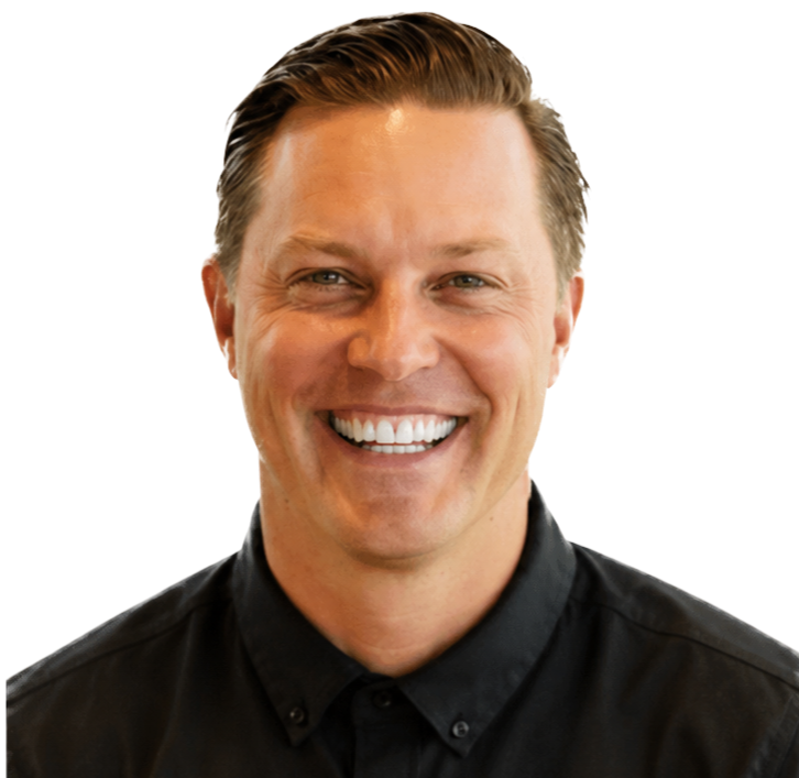 Headshot of Nik Hennessee with short, slicked-back hair, wearing a black collared shirt.