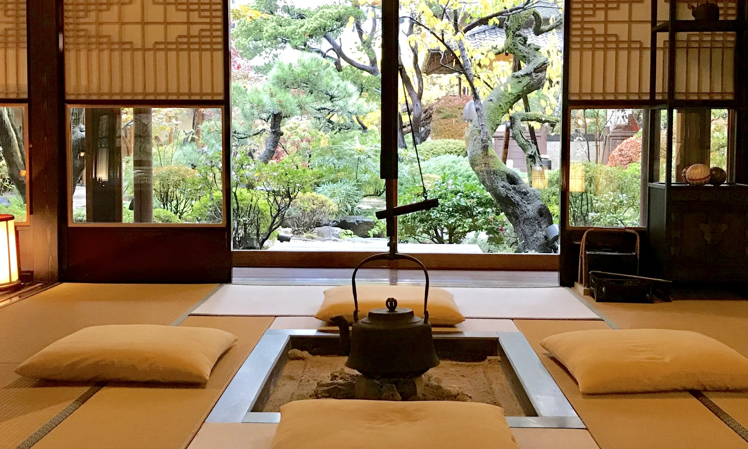 Interior of a Japanese tea house with an open fire, overlooking a traditional garden, captured by Will.