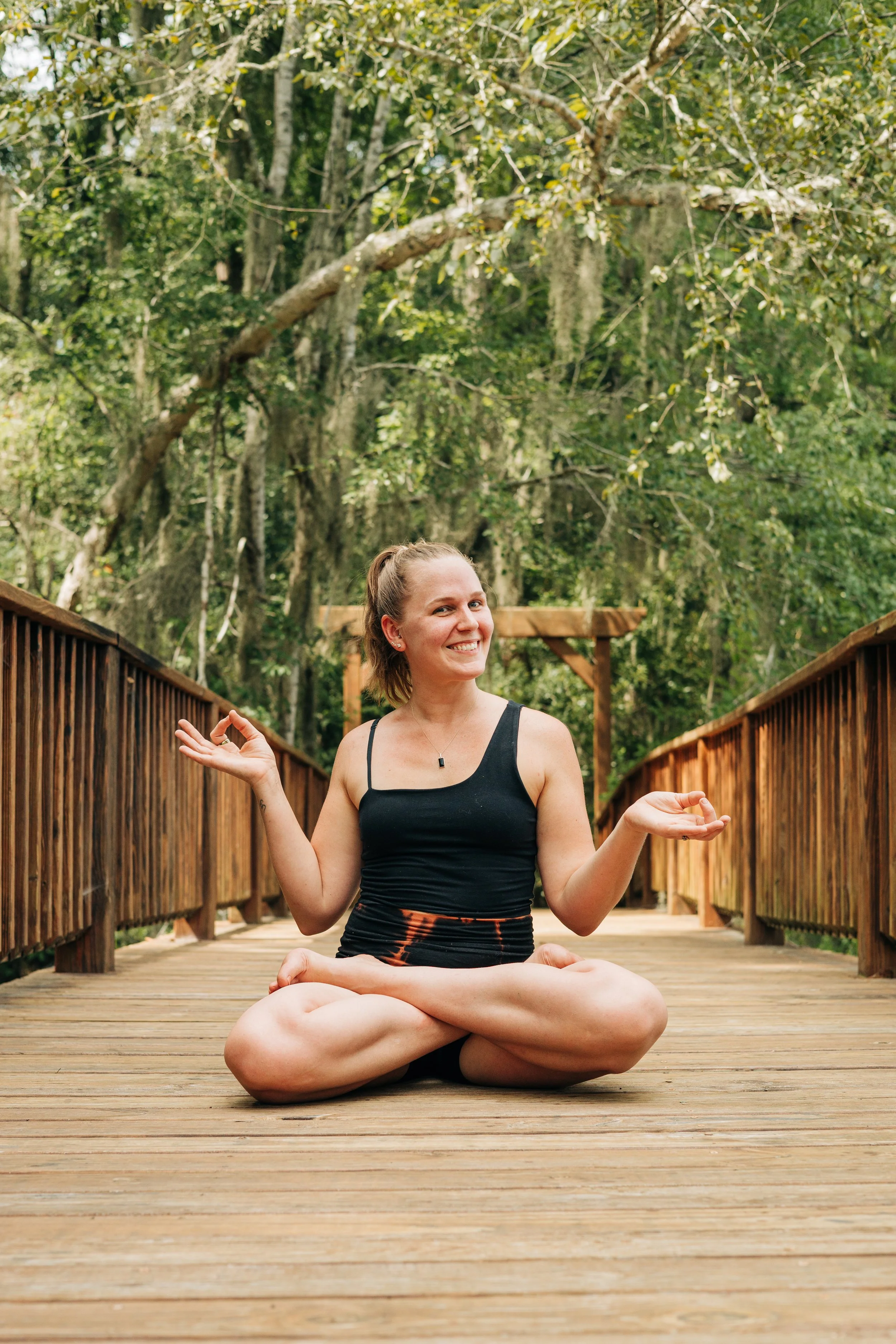 Yoga Teacher Laura  in a posture outside smiling looking happy and playful