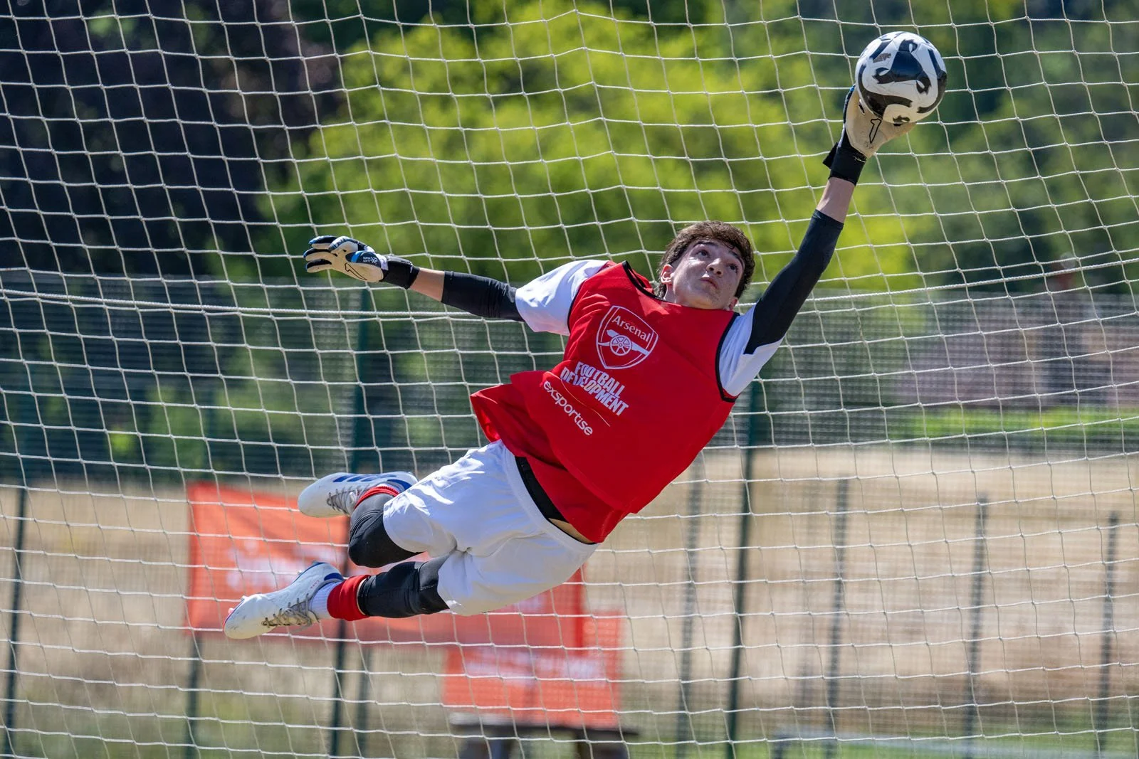 A goalkeeper diving at an Arsenal camp.