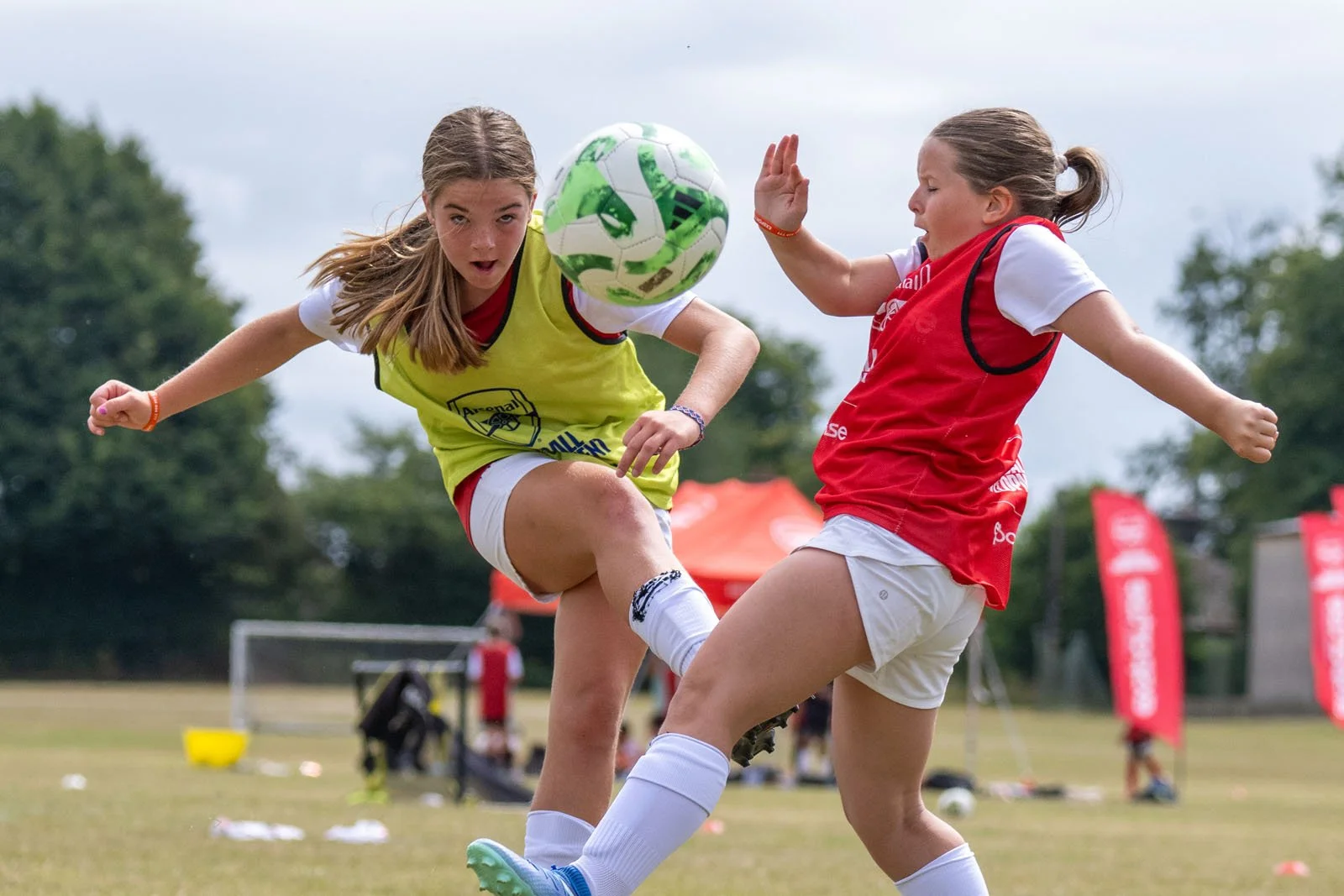 Two girls playing football at an Arsenal camp.