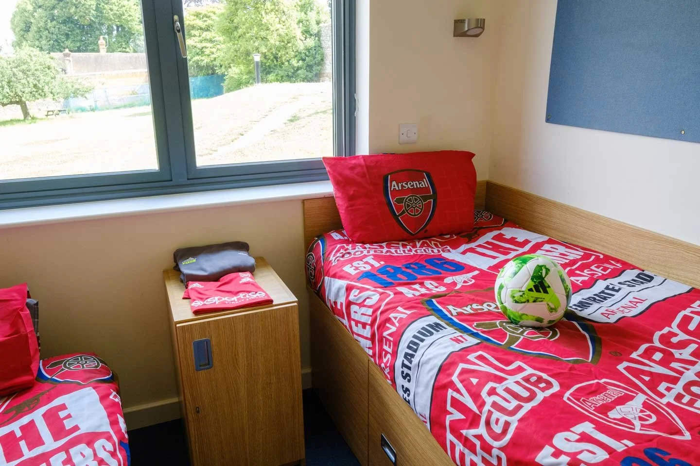 A bded with arsenal bedding at an exsportise camp
