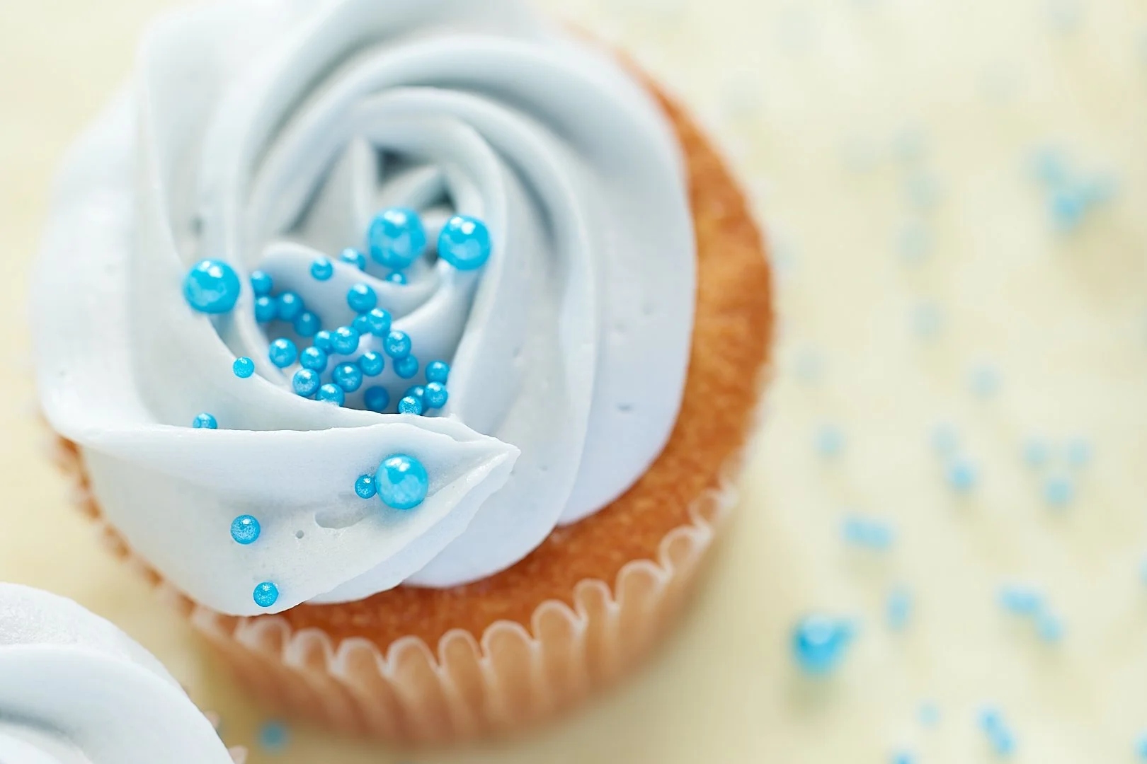 Cupcake with light blue frosting and blue sugar pearls
