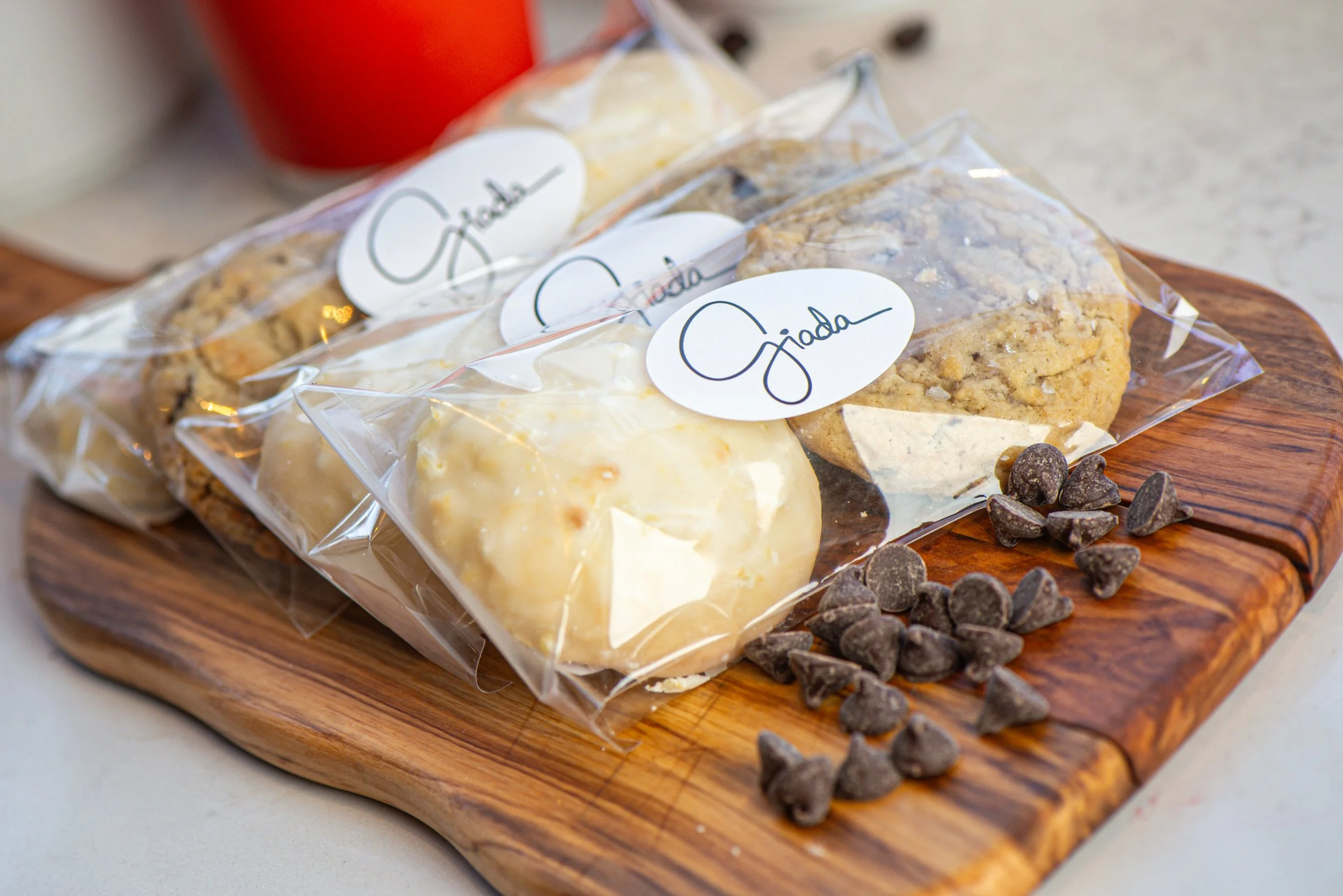 Packaged cookies on wooden board with chocolate chips.