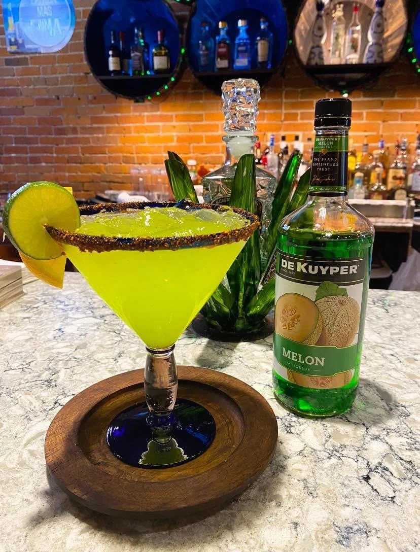 Lime green margarita with tajin around the rim of the glass.